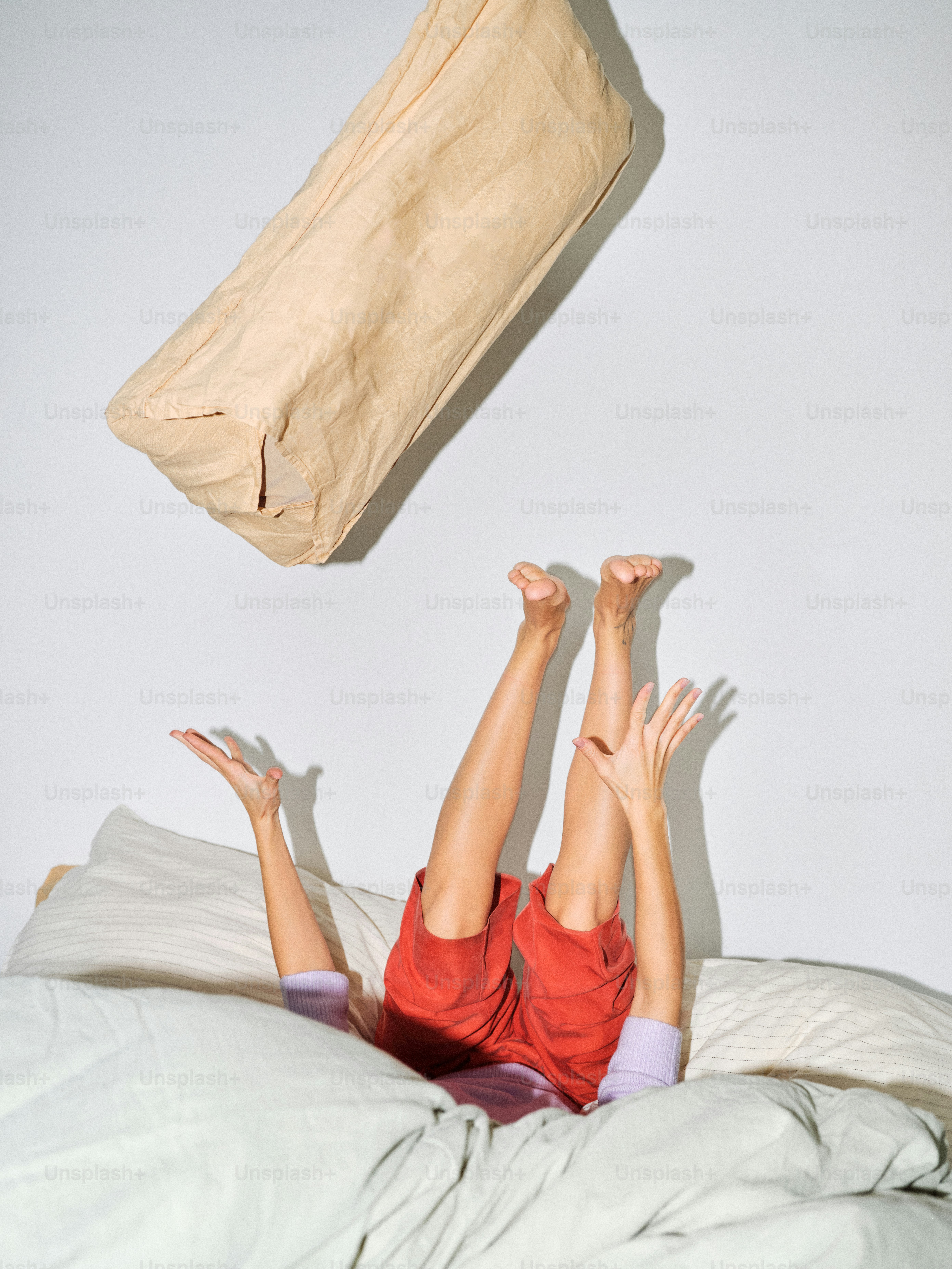 Woman falling out of bed with pillow
