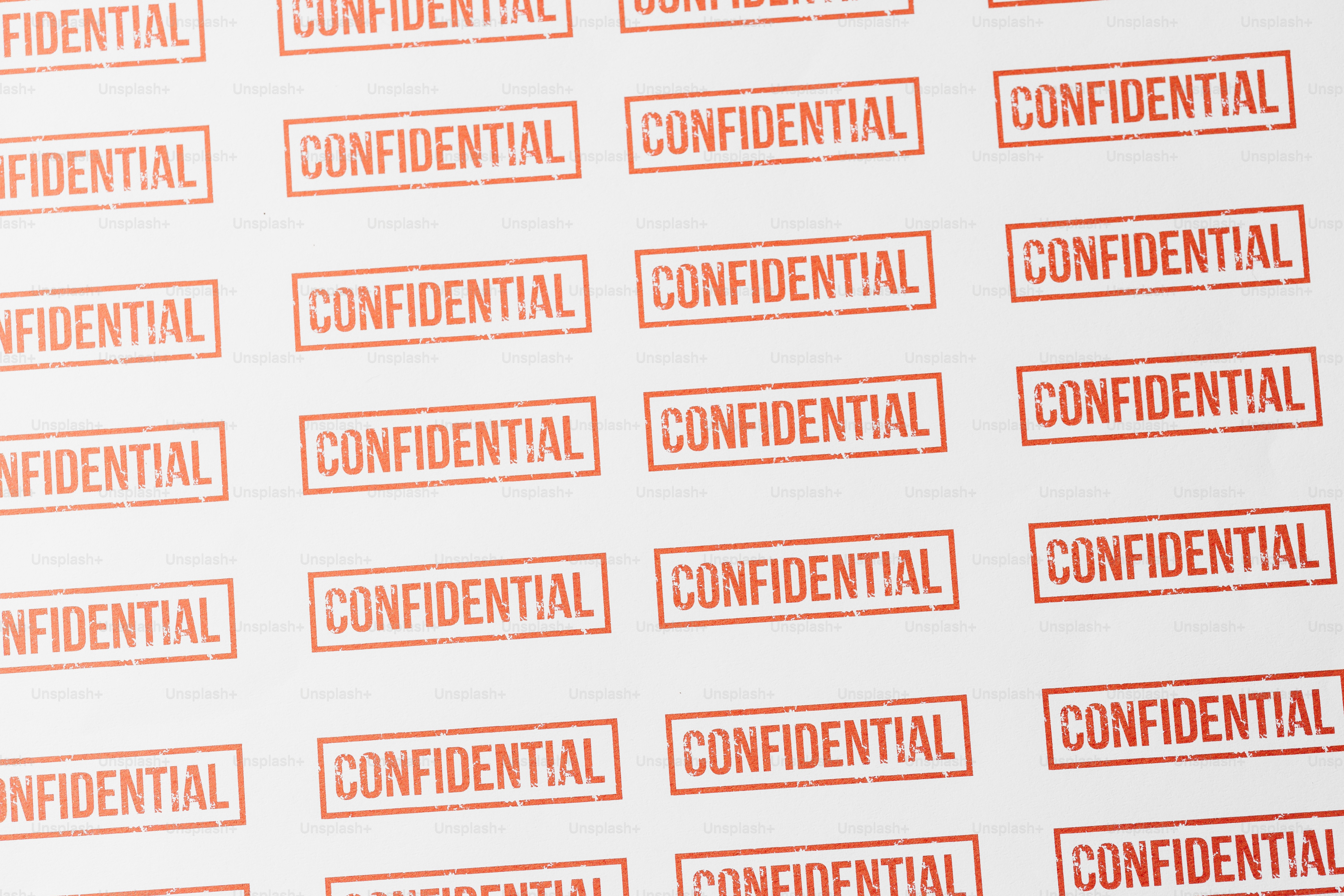 Beaucoup de timbres rouges avec le mot confidentiel sur papier blanc.