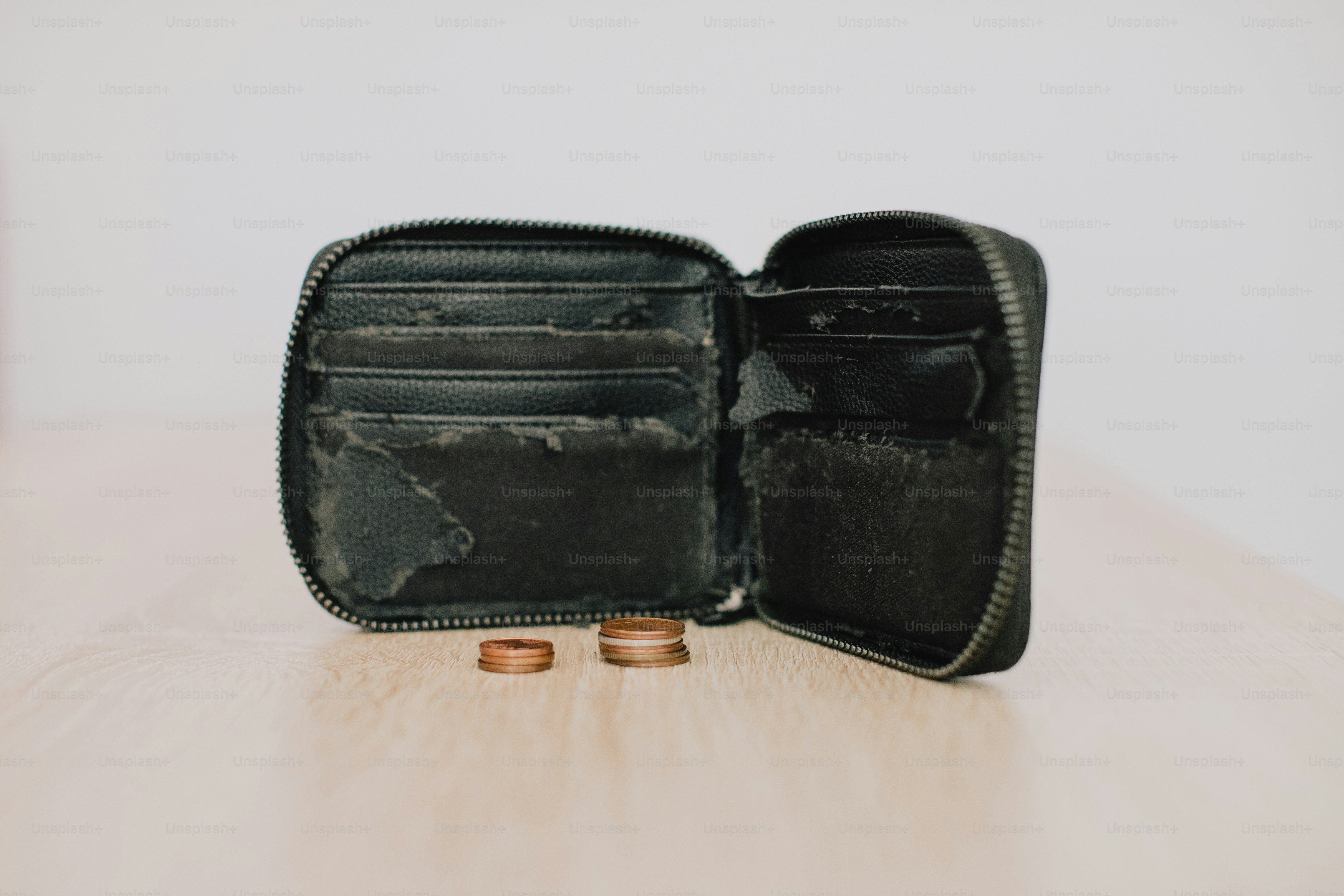 Eine offene schwarze Brieftasche mit zwei Münzen auf dem Tisch