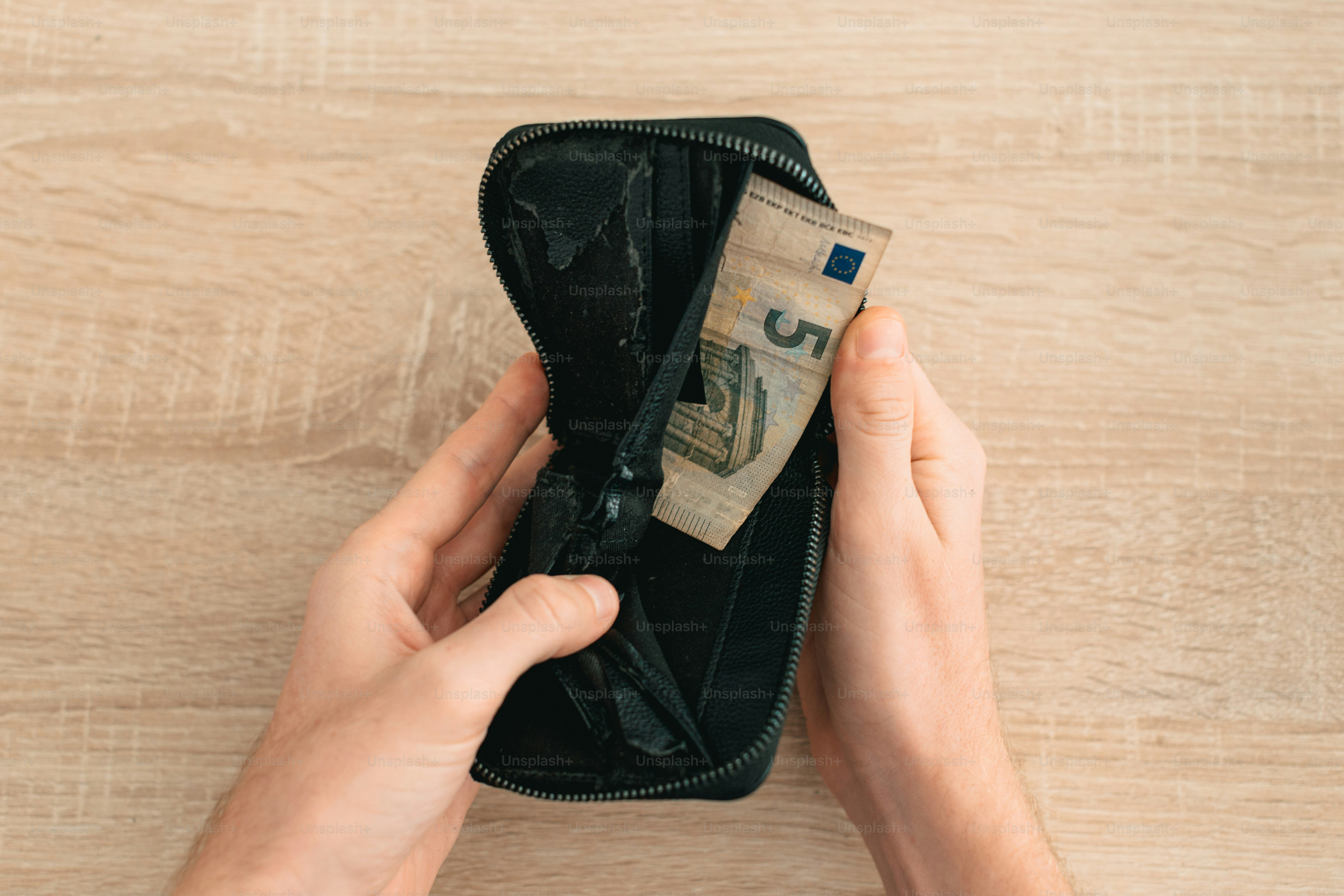 Hände, die eine Brieftasche mit Euro-Banknoten darin halten