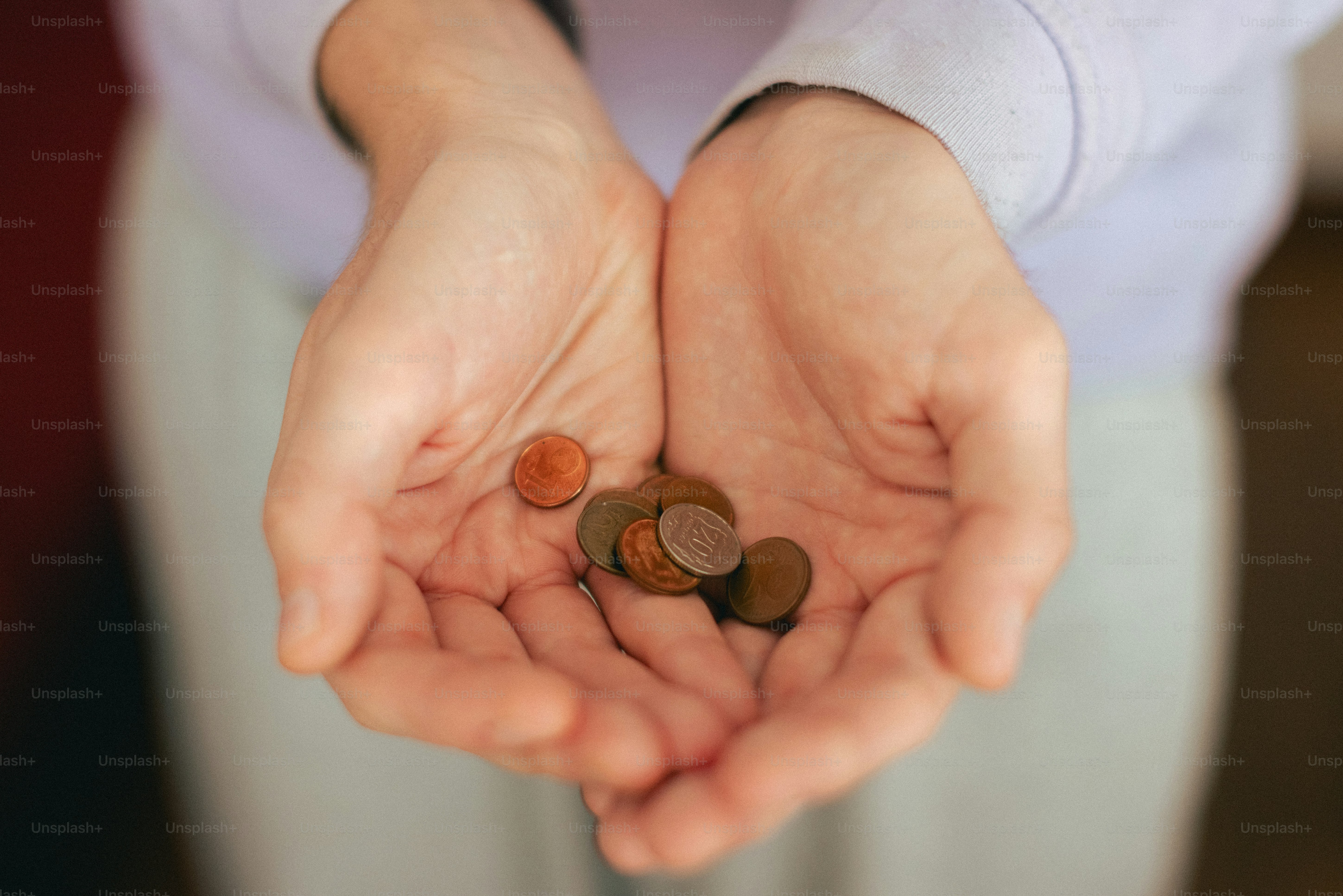 Cupped hands holding a few coins