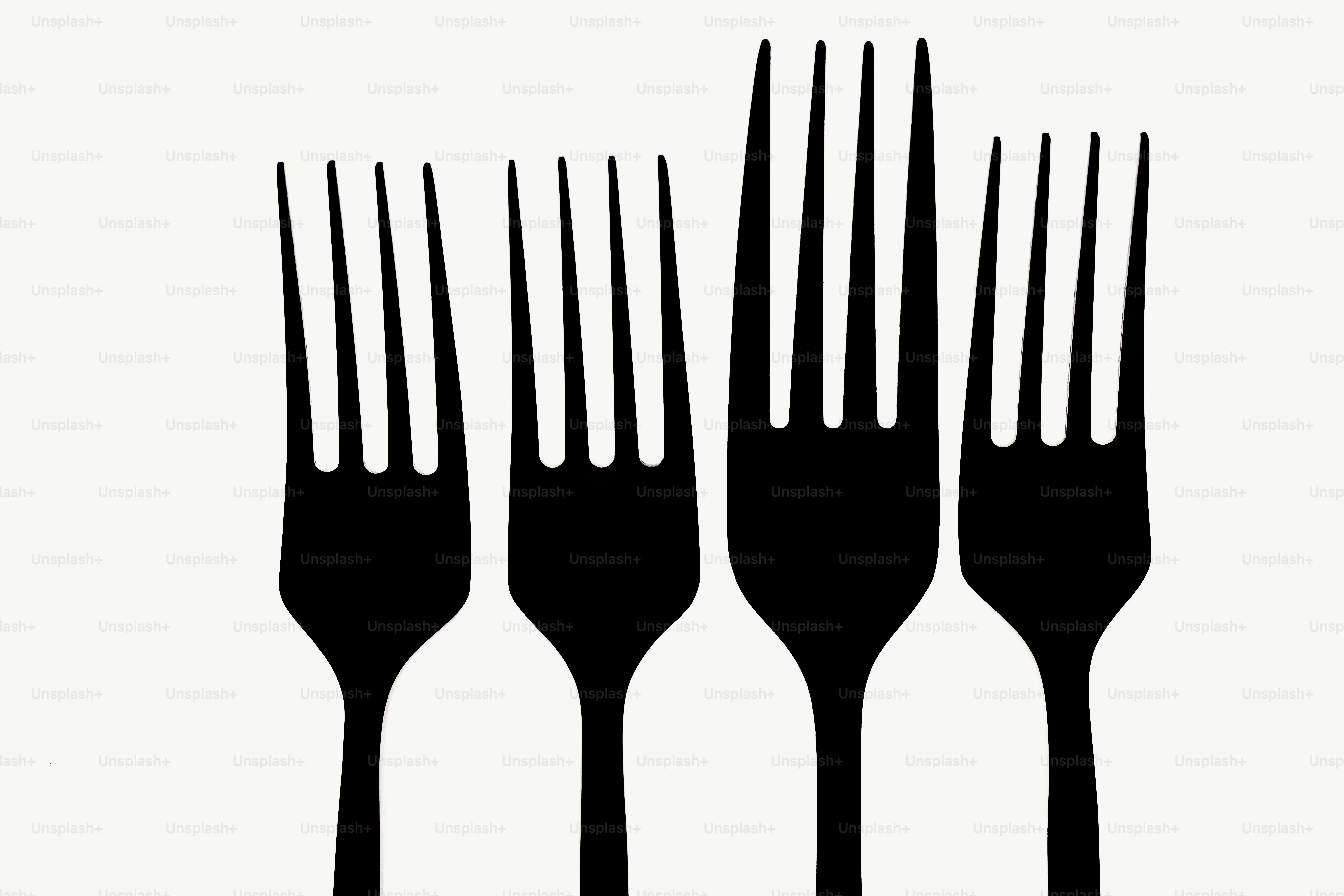 Four black forks of varying heights on white