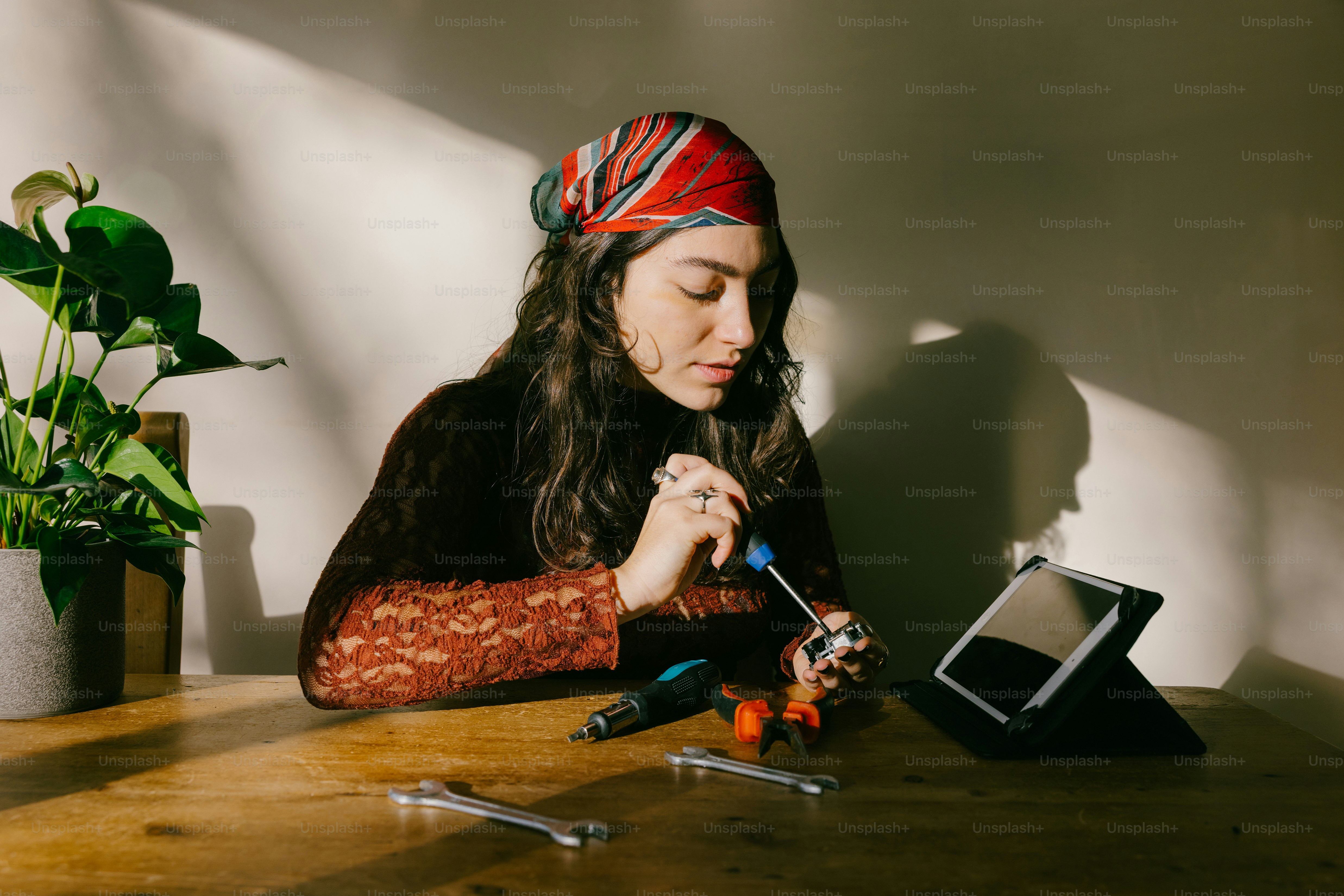 Woman fixing small object with tools and tools