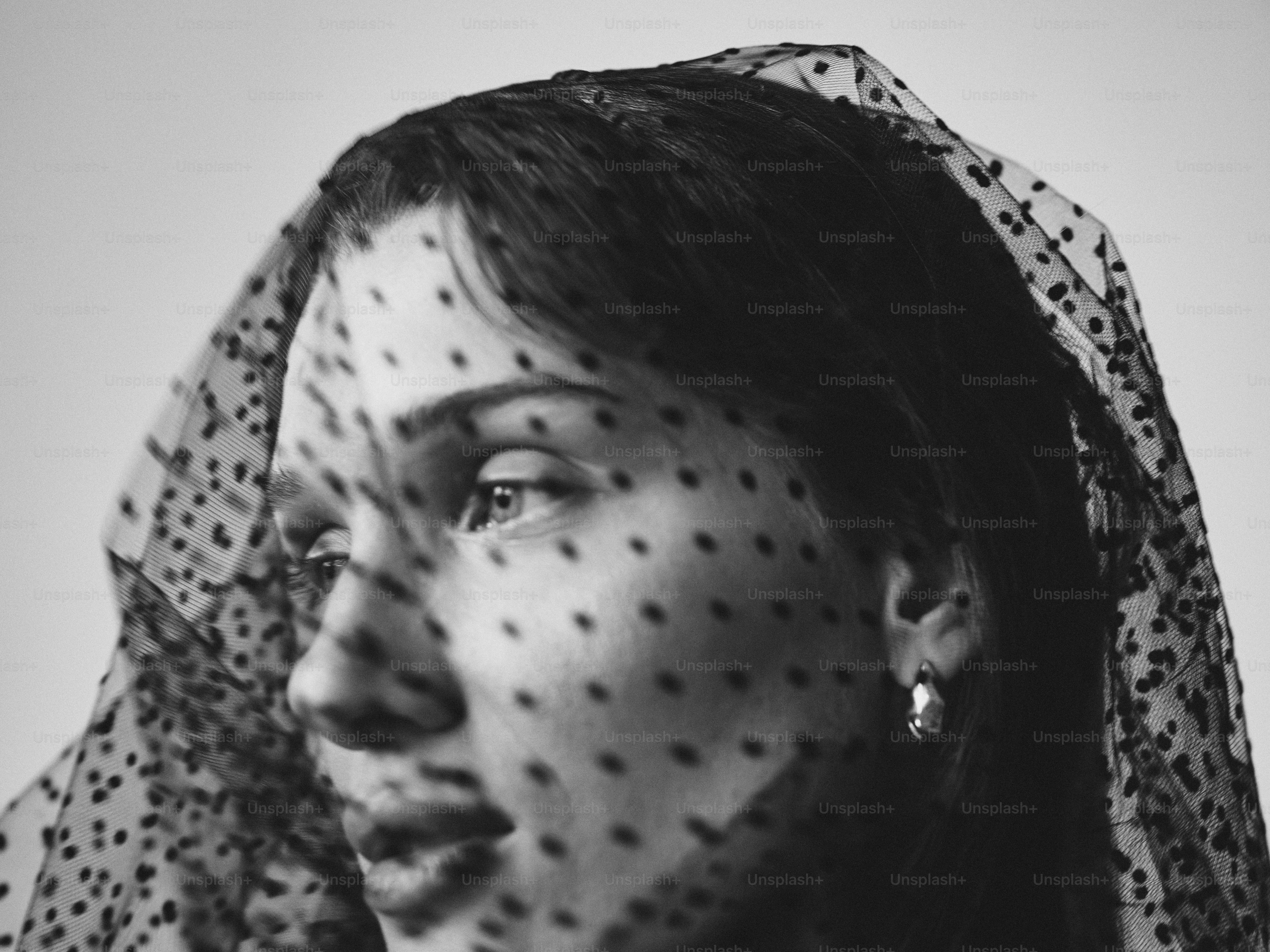 Woman with polka dot veil covering face
