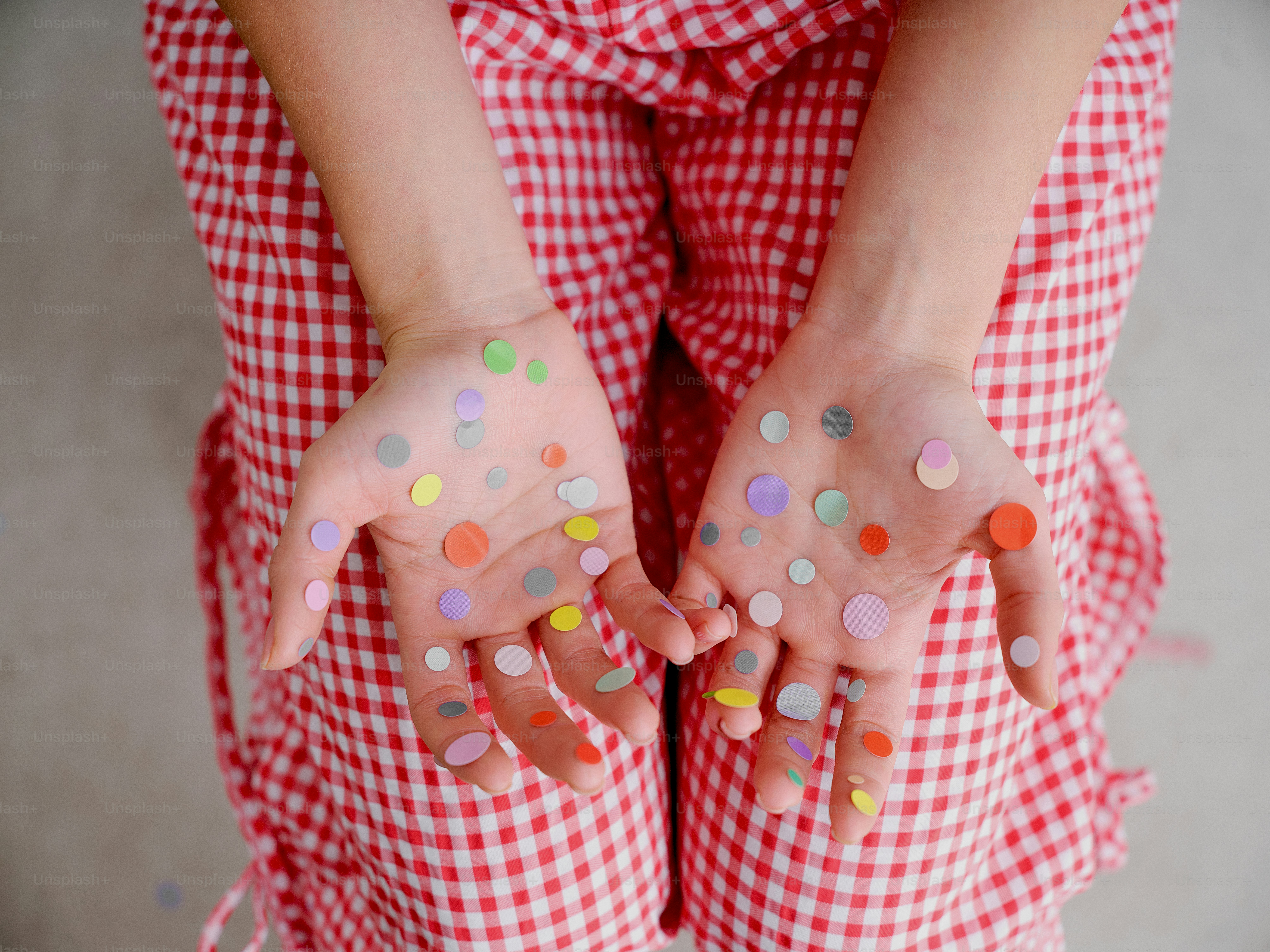 Child's hands covered in colorful stickers.