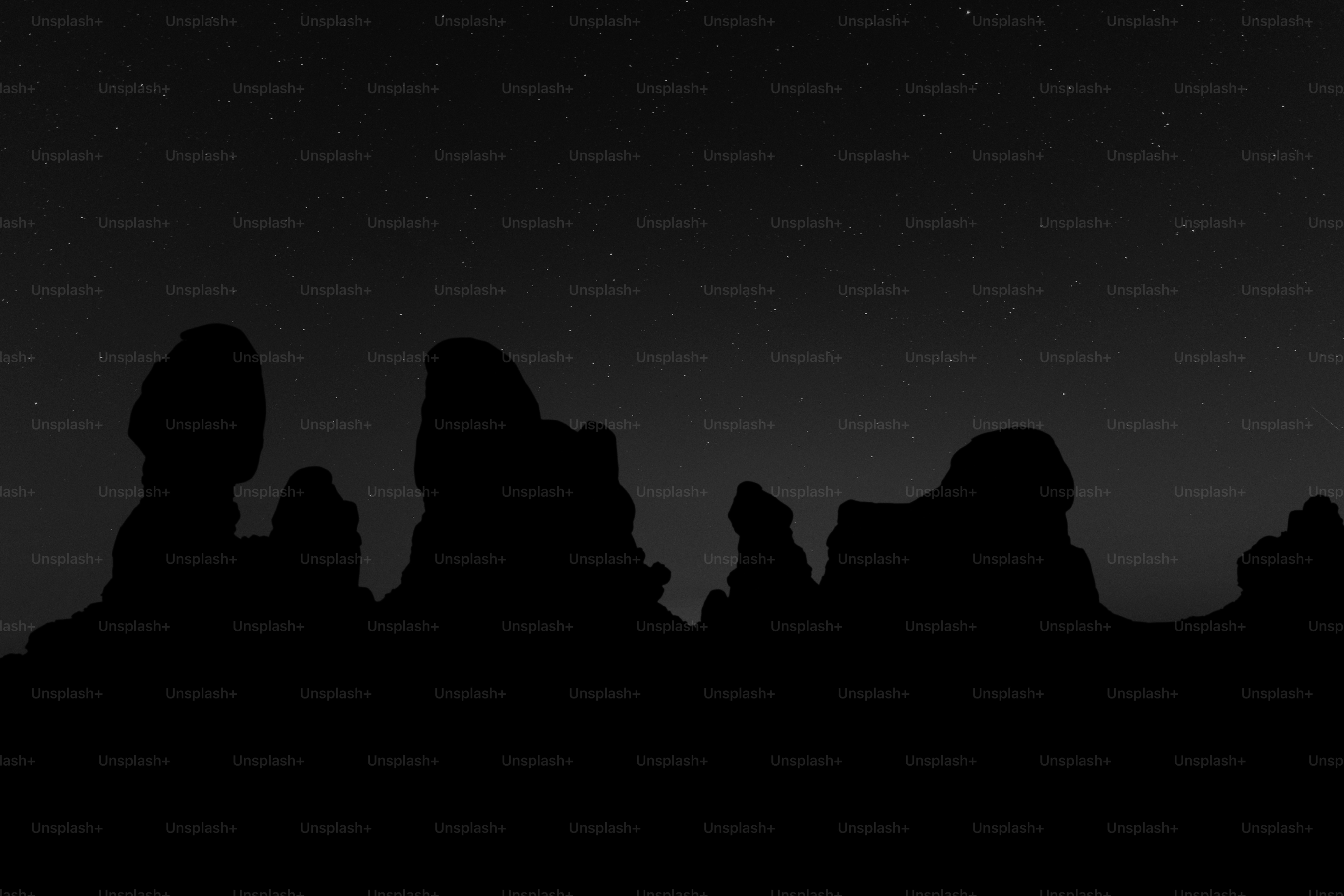 Silhouette of rock formations under a starry night sky