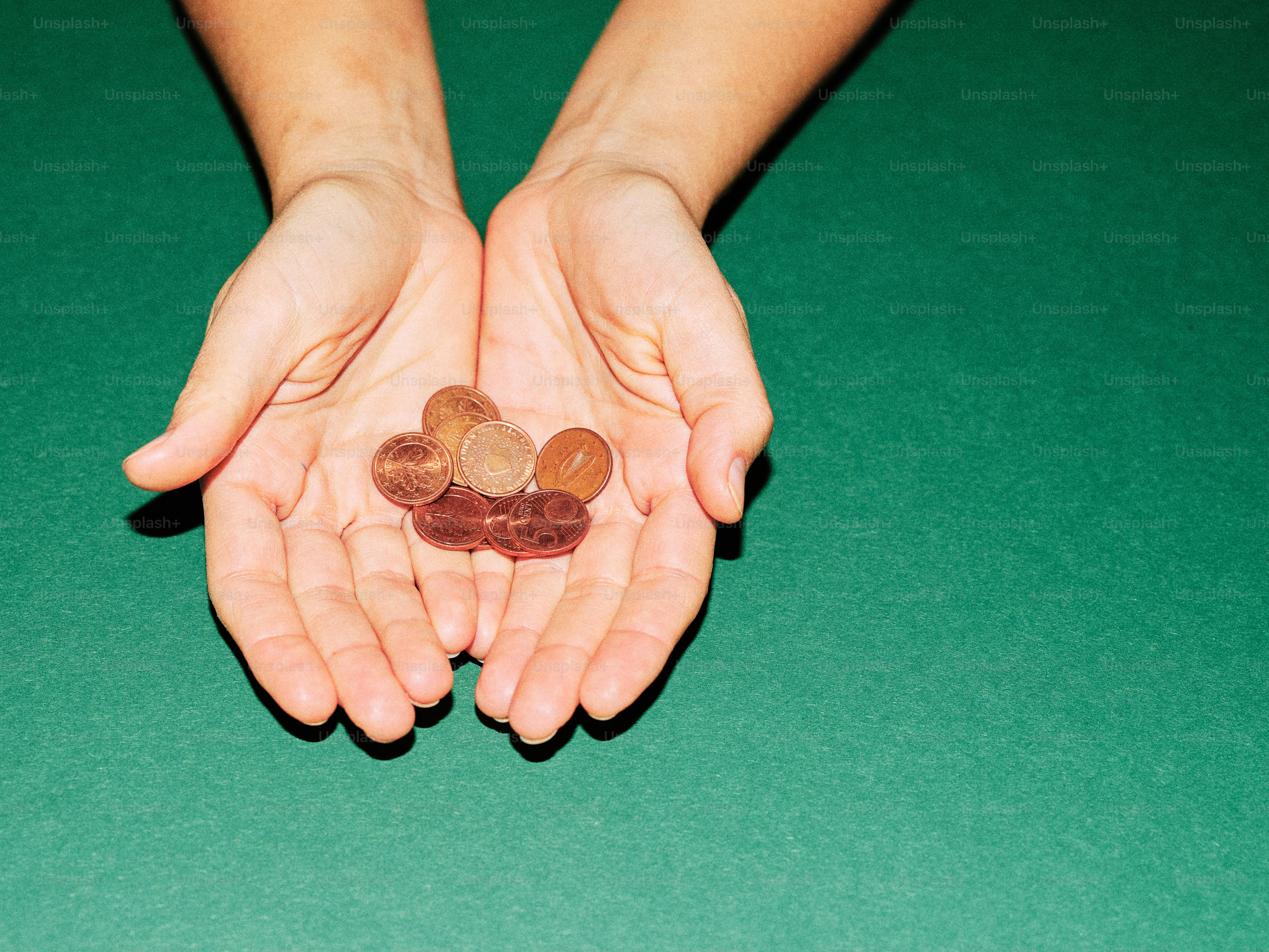 Hands holding a few copper coins
