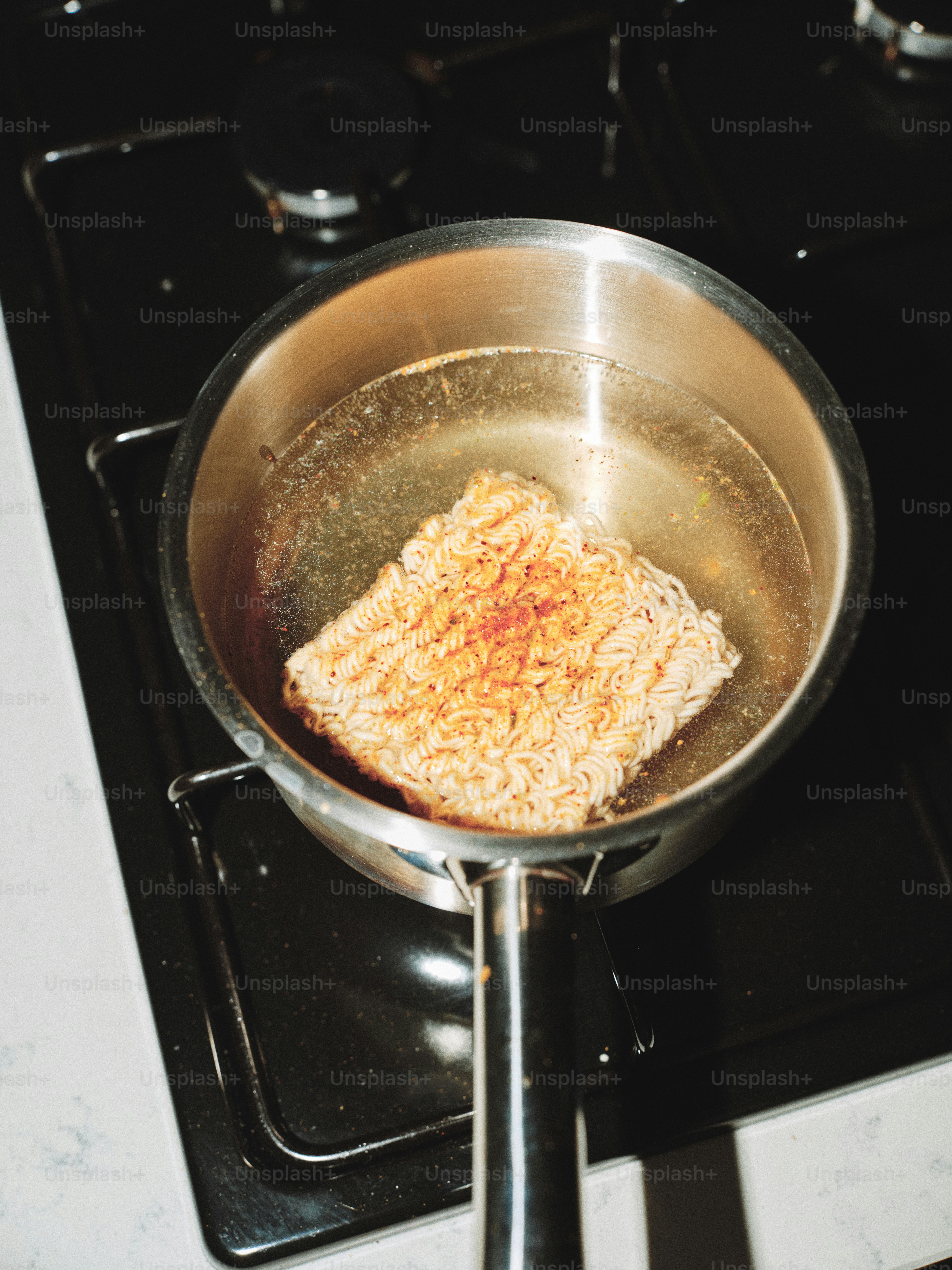 Instant noodles cooking in a pot of boiling water.