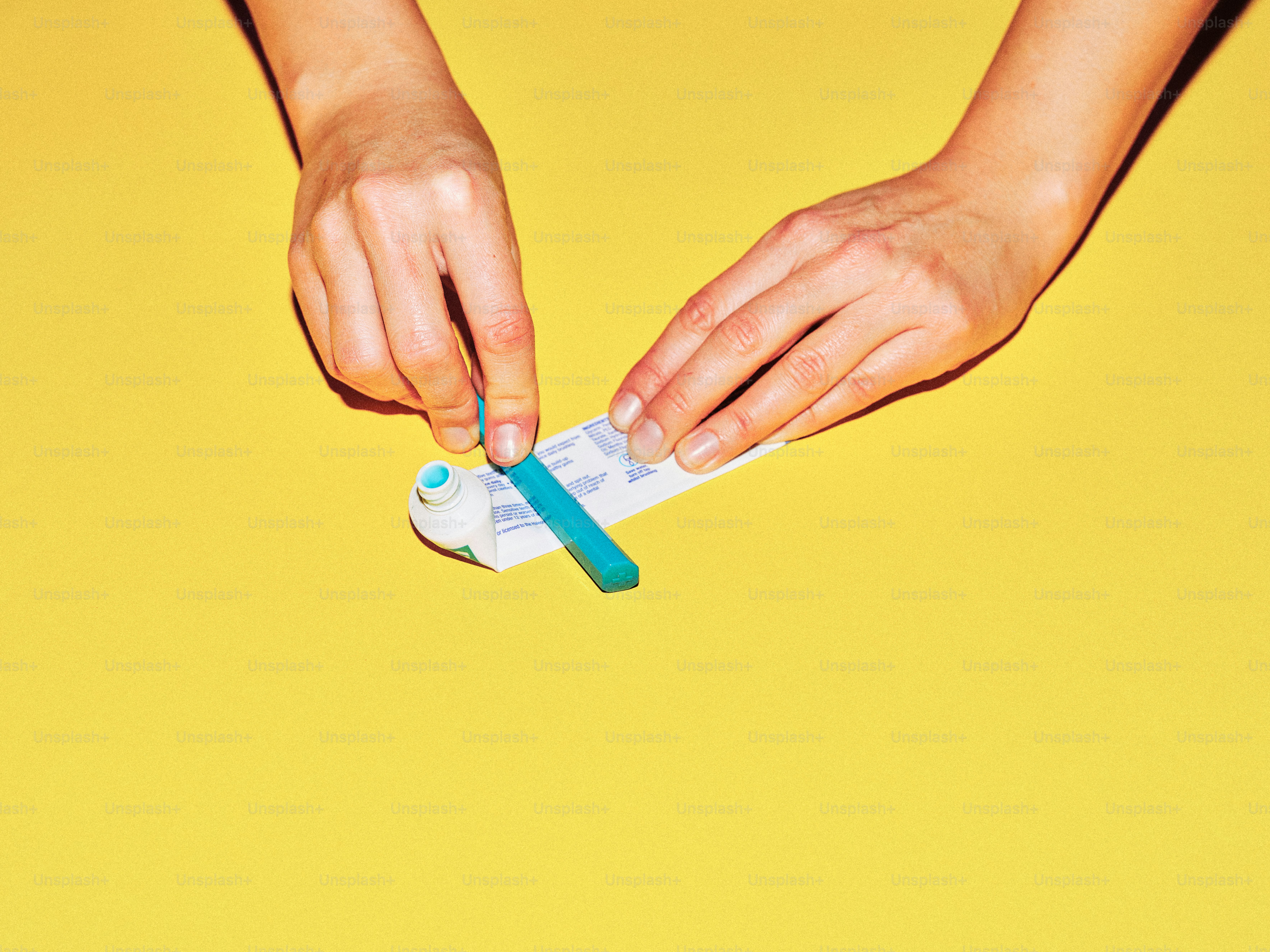 Mains ouvrant un tube de dentifrice avec un outil