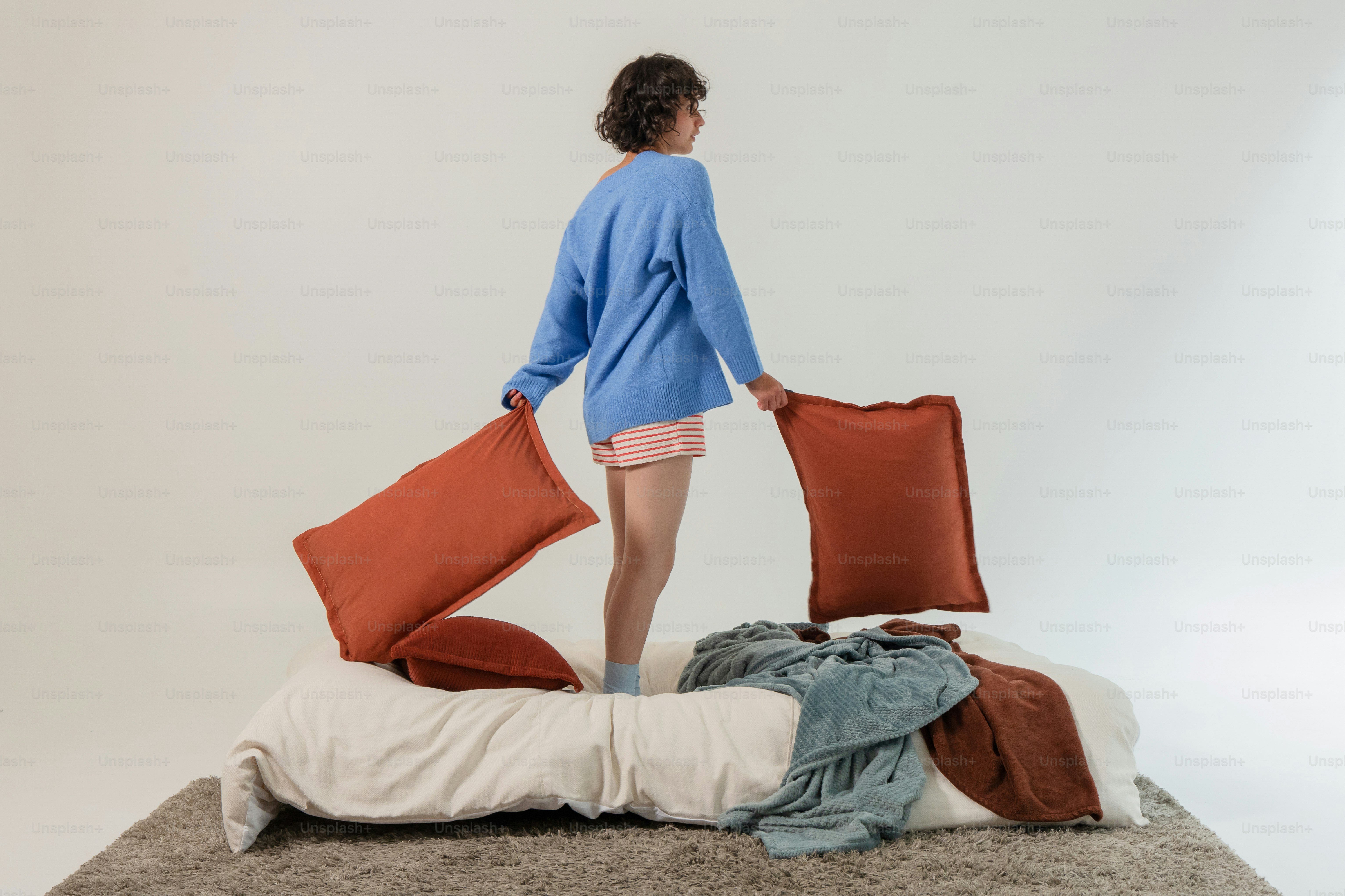 Mujer de pie en una cama con almohadas