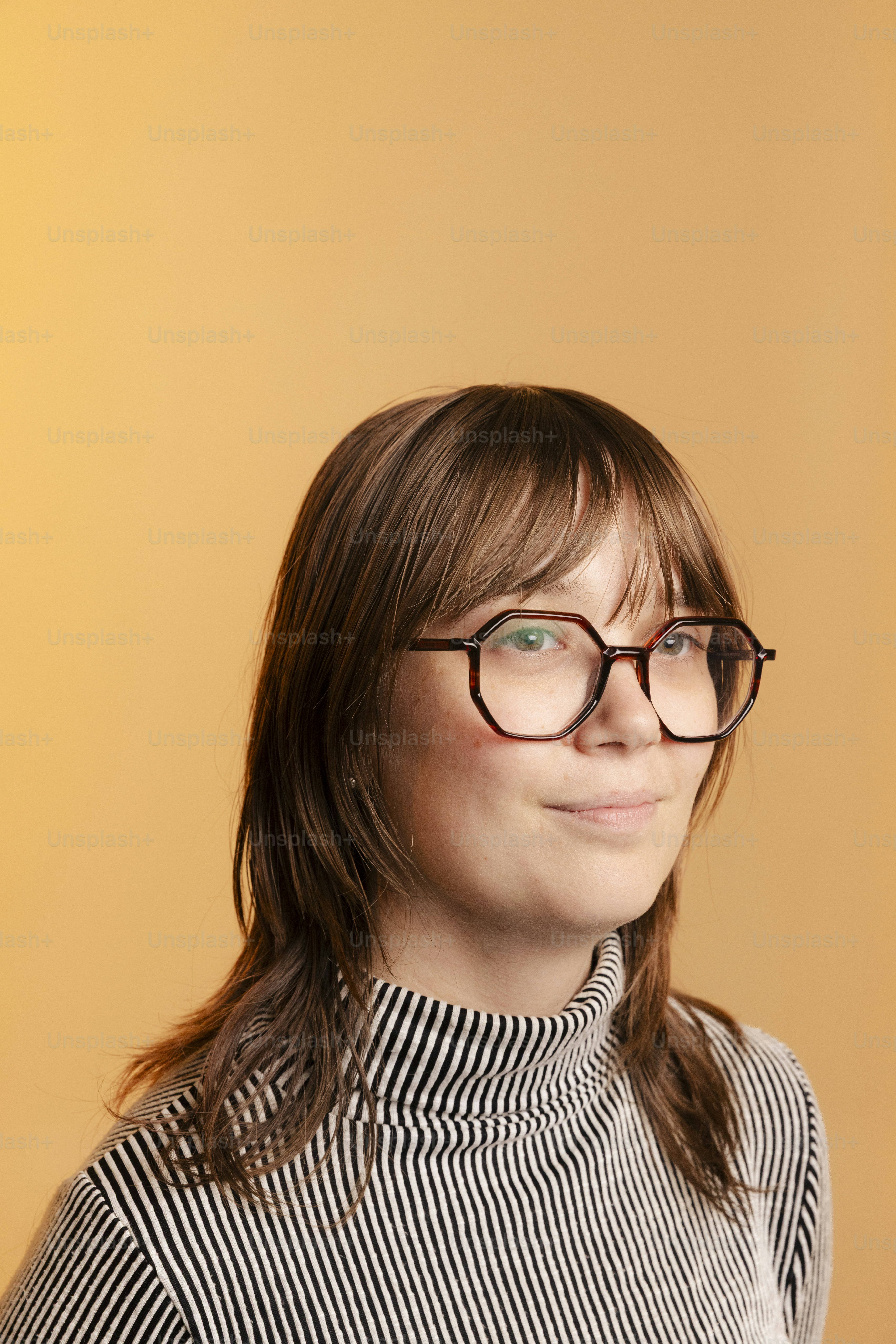 Mulher de óculos sorri contra fundo laranja