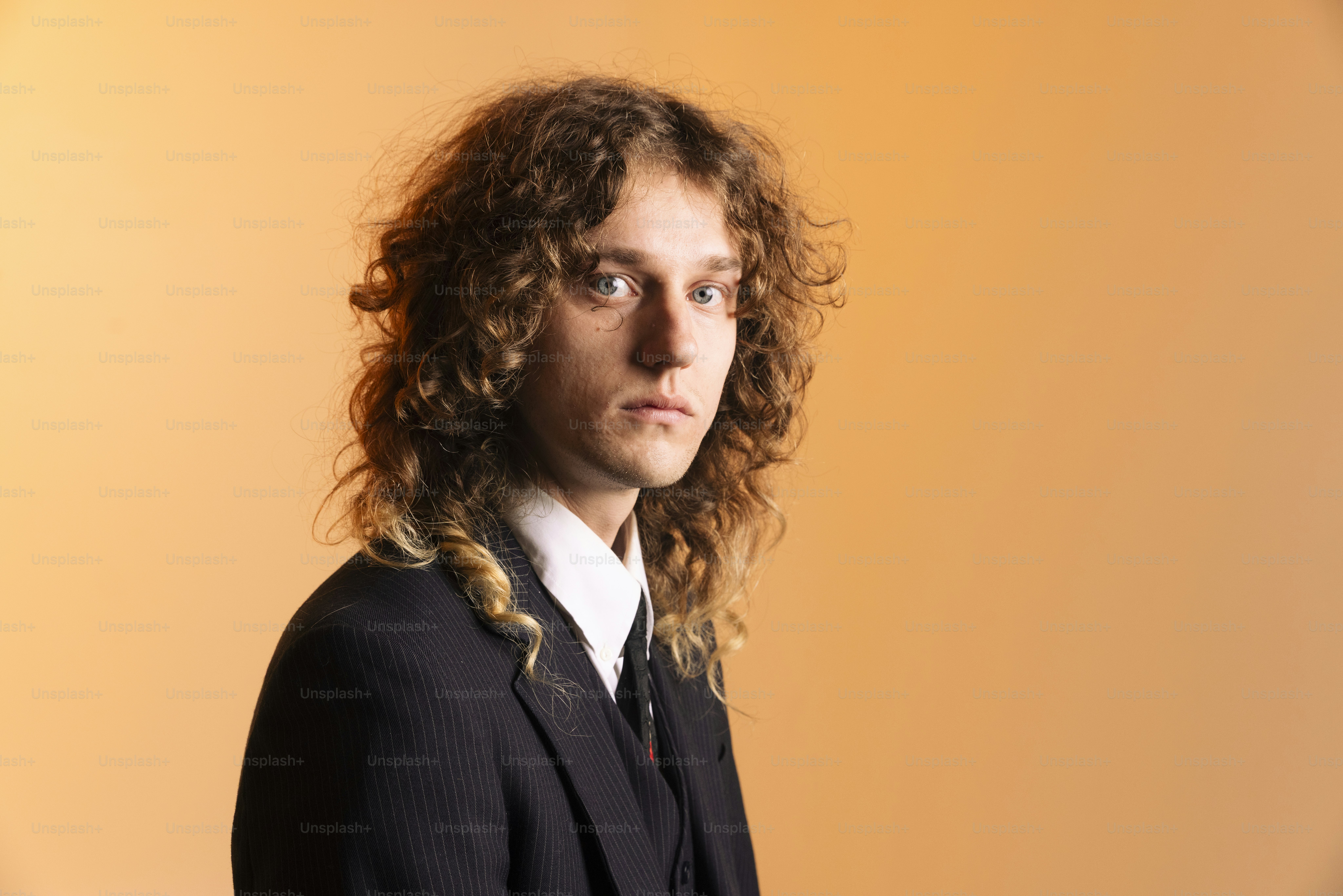 Man with curly hair in a suit