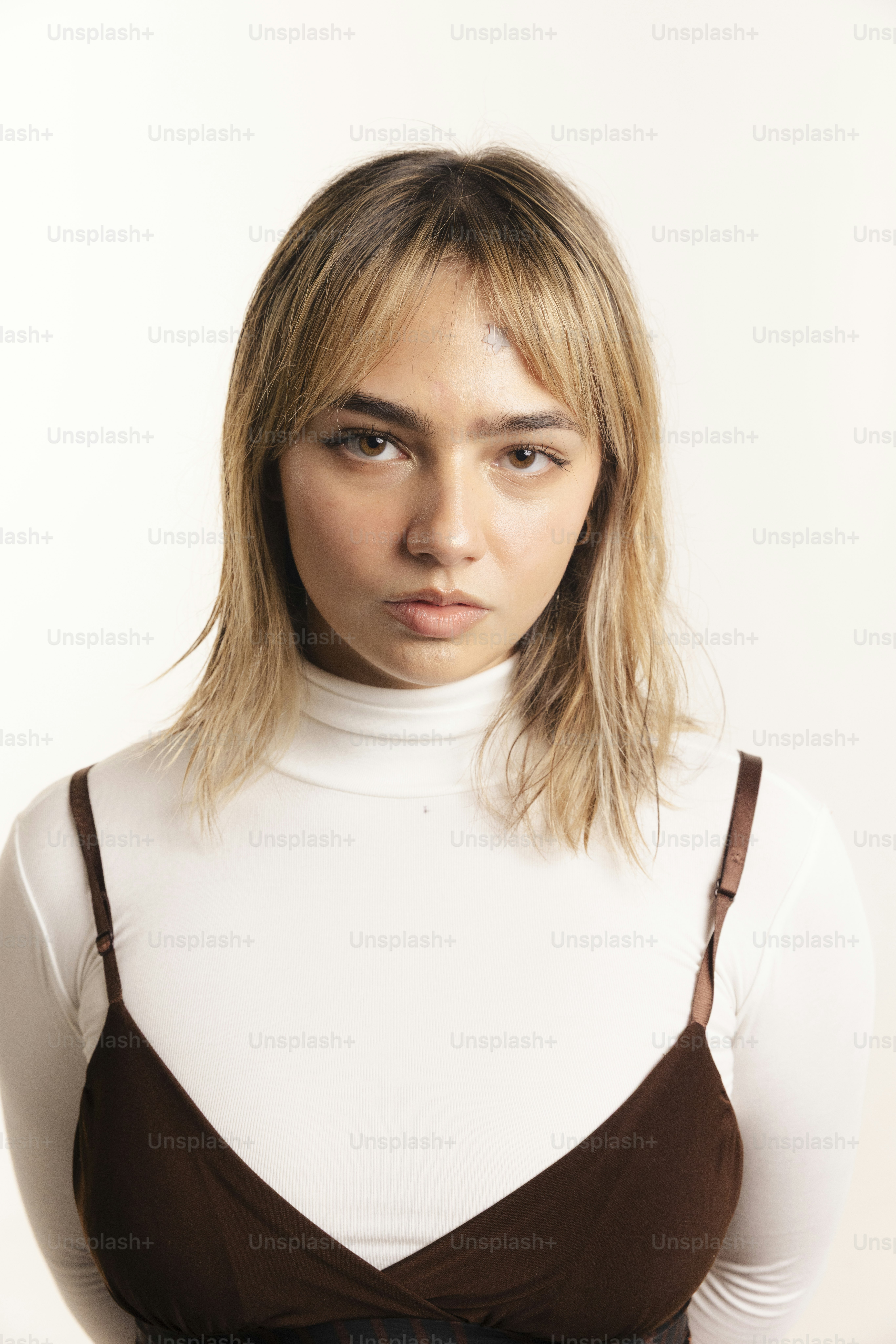 Young woman with blonde hair wearing a white turtleneck.