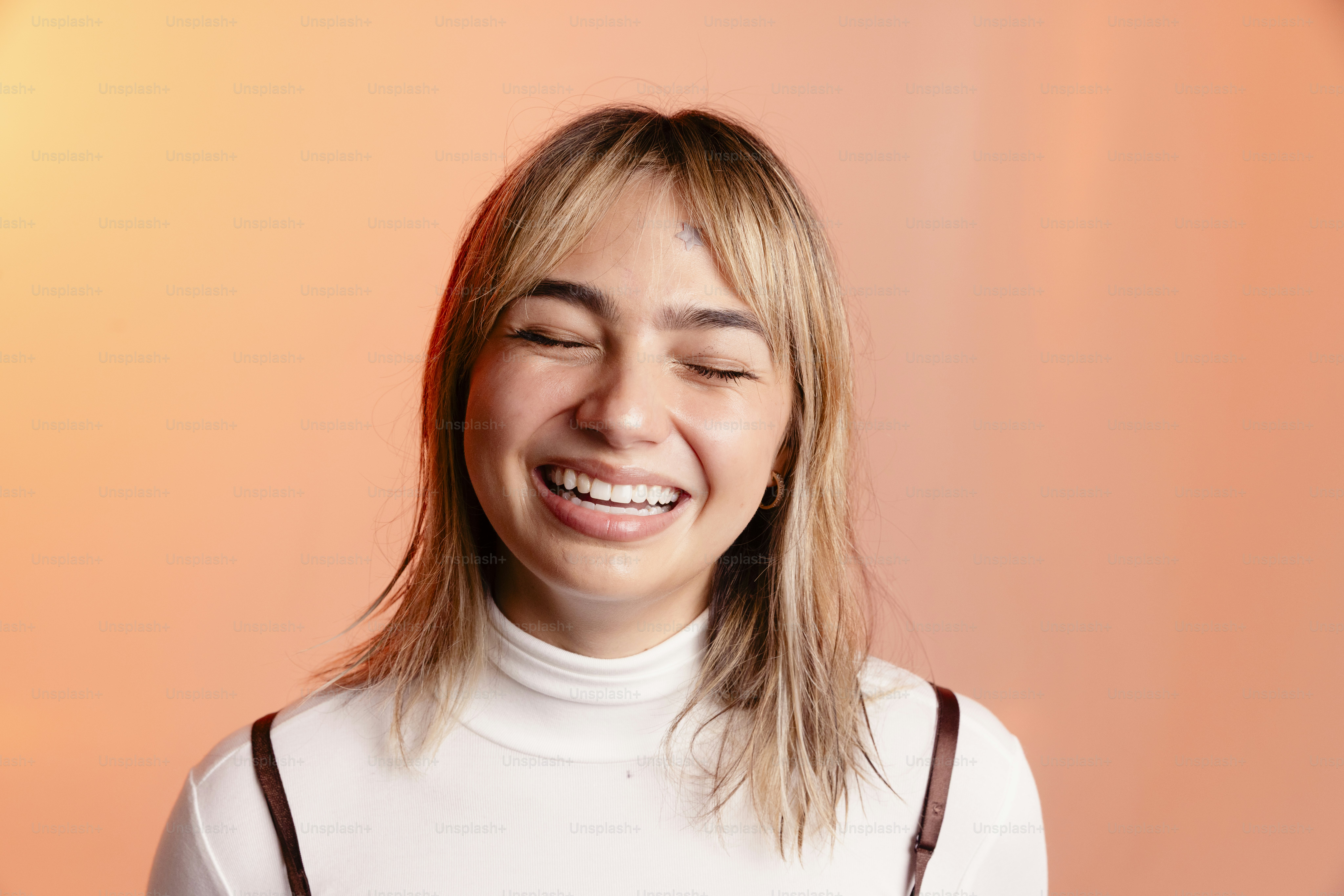 Uma jovem de olhos fechados rindo