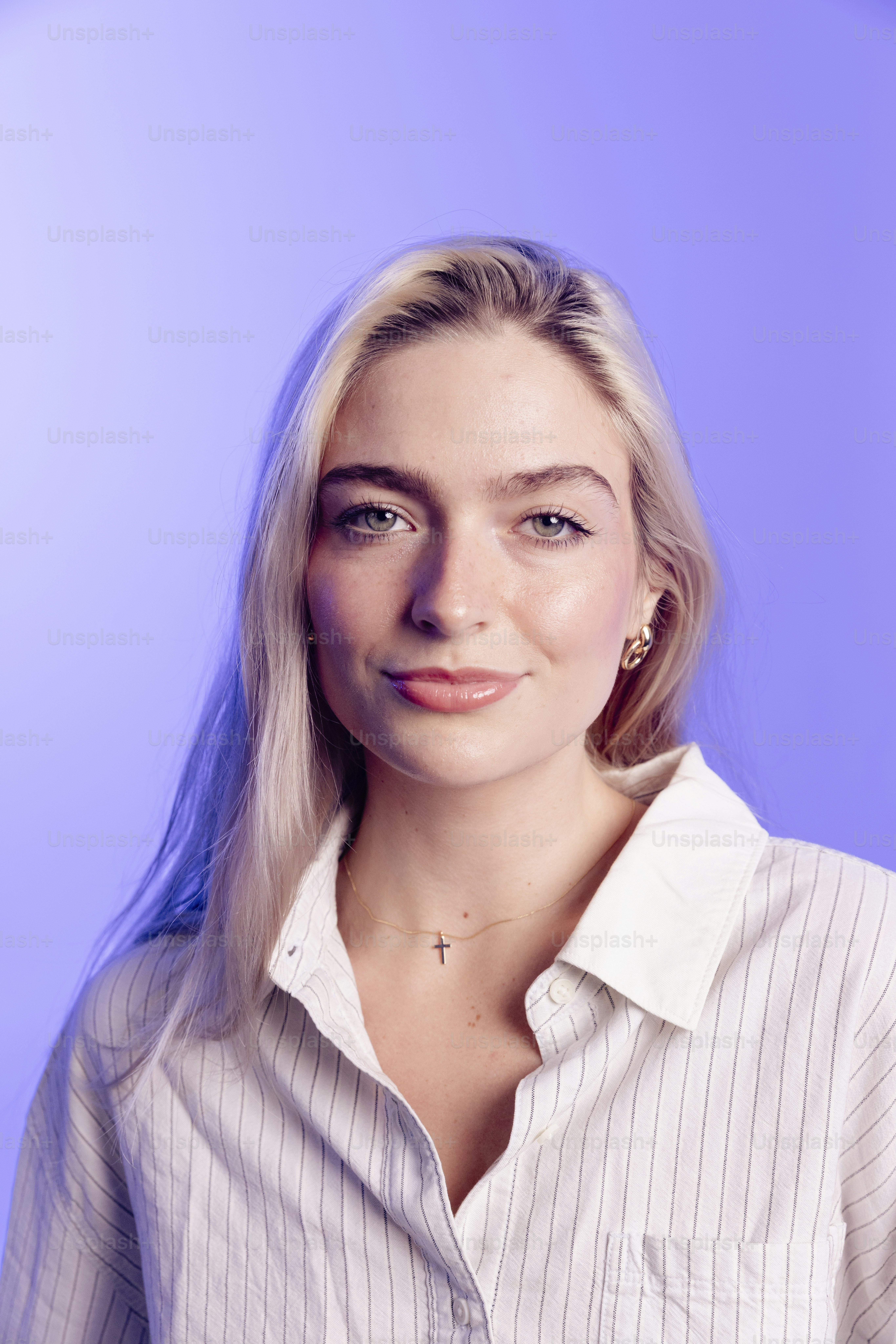 Uma jovem loira usando uma camisa listrada.