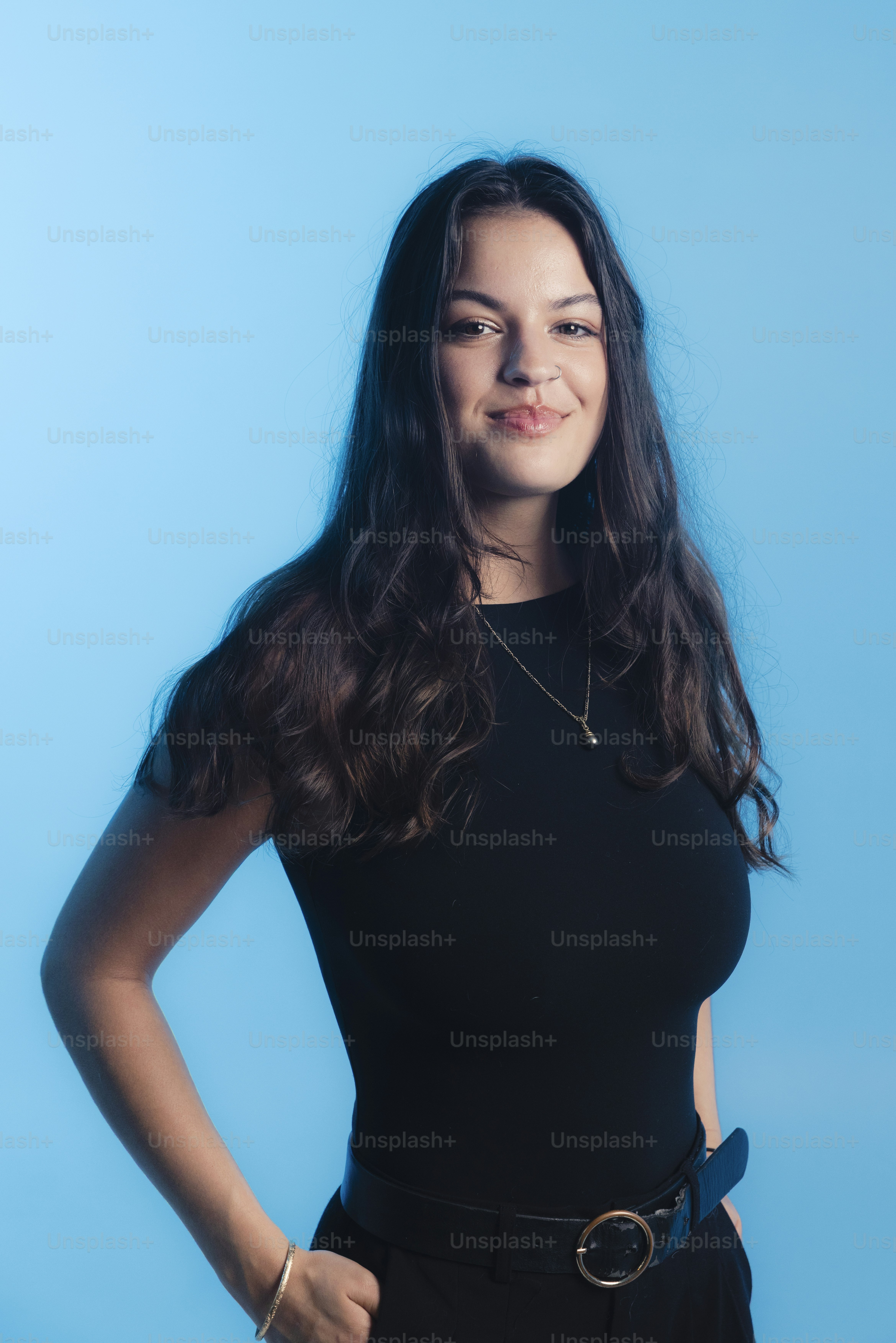 Jovem mulher de cabelo escuro e ondulado sorri