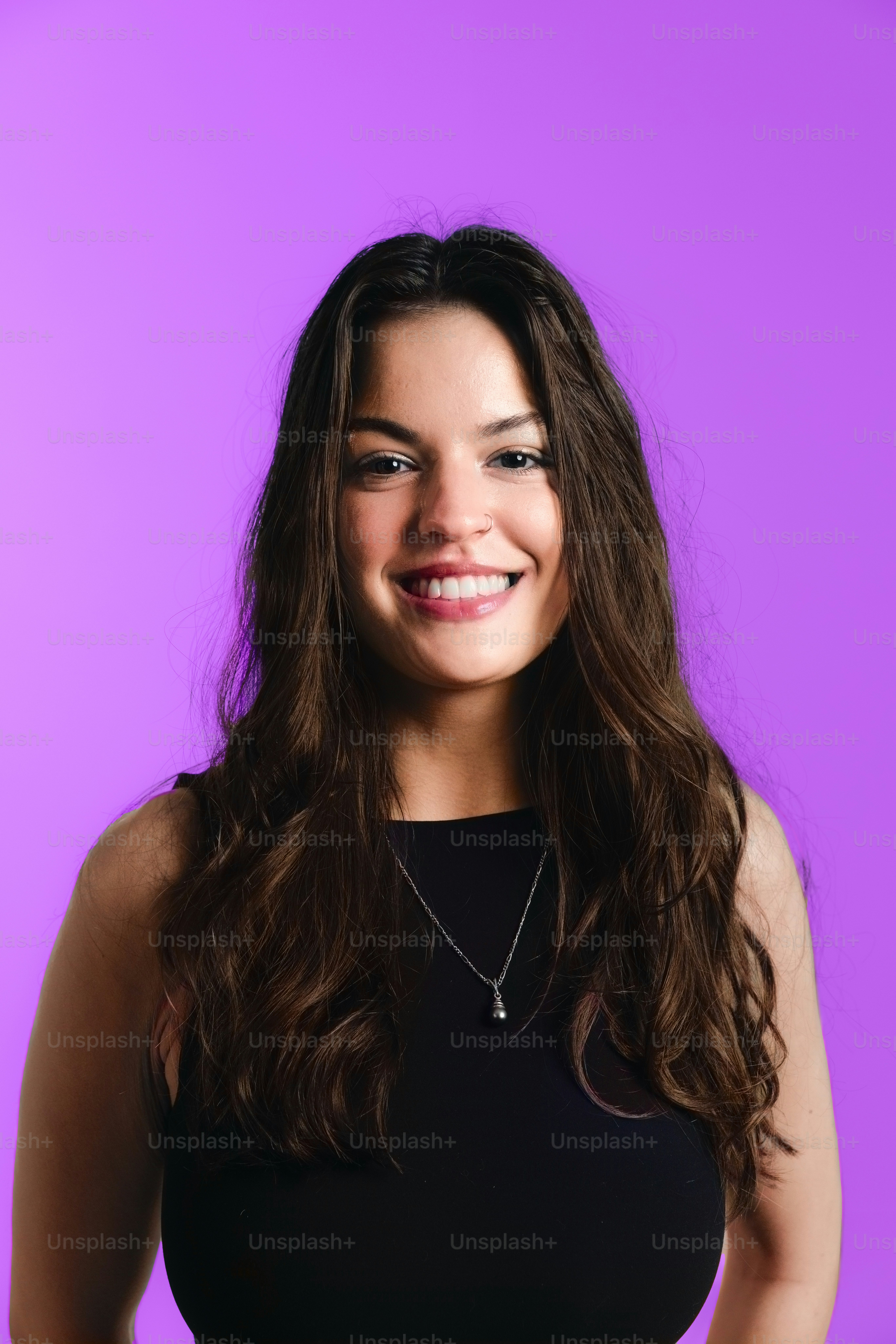 Uma jovem sorridente de cabelos longos e escuros.