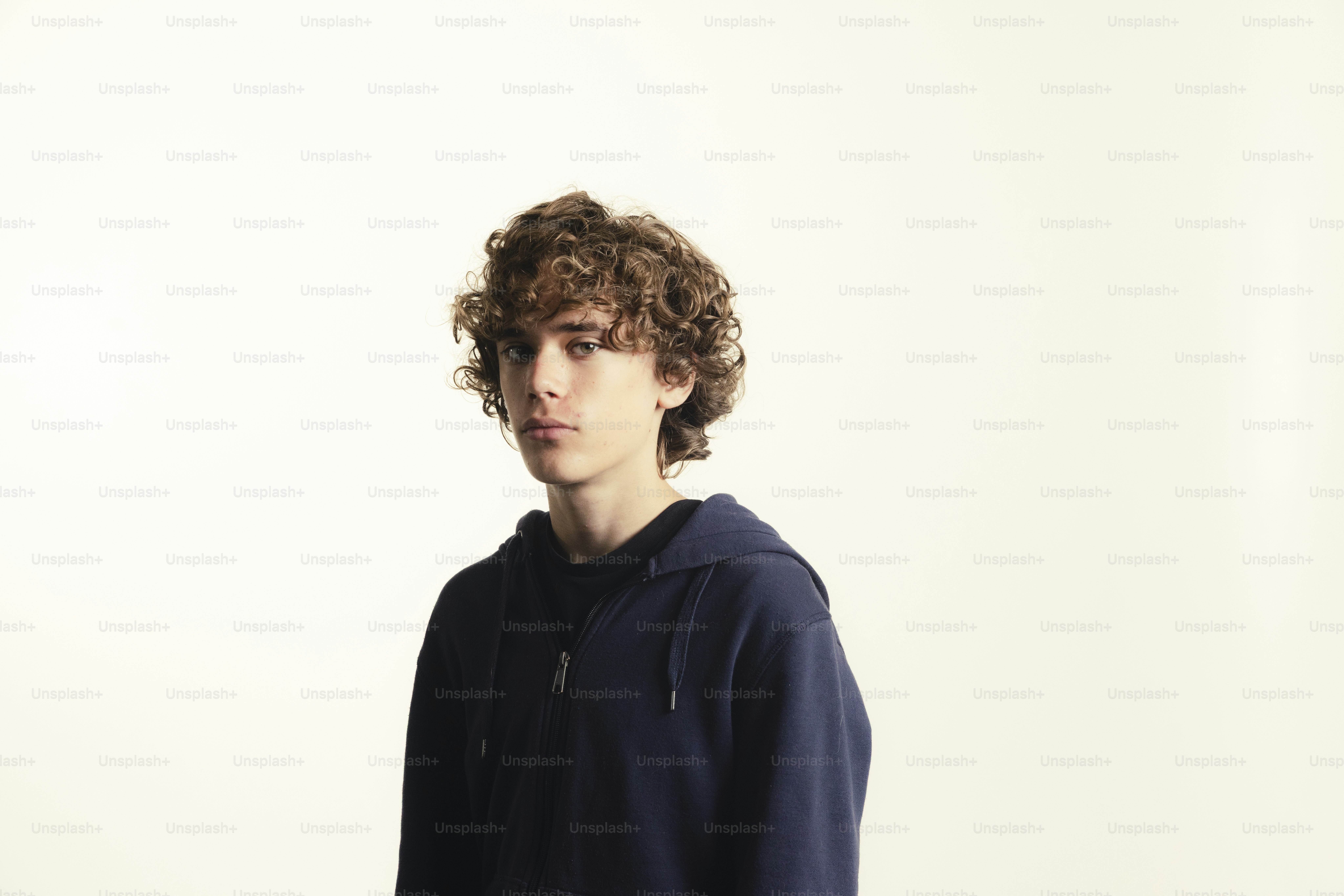 Young man with curly hair wearing a hoodie.