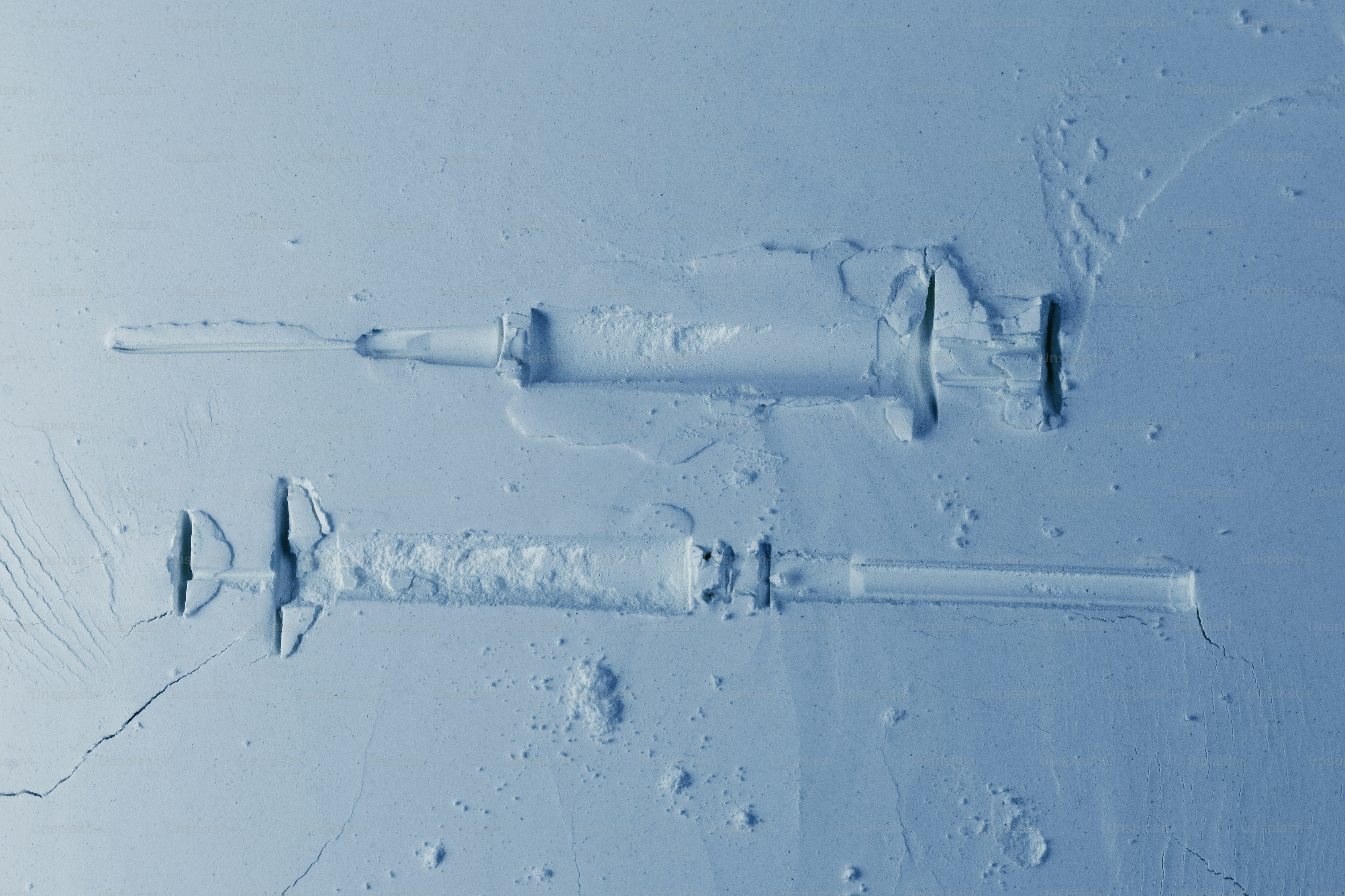 Two syringes on a light blue background