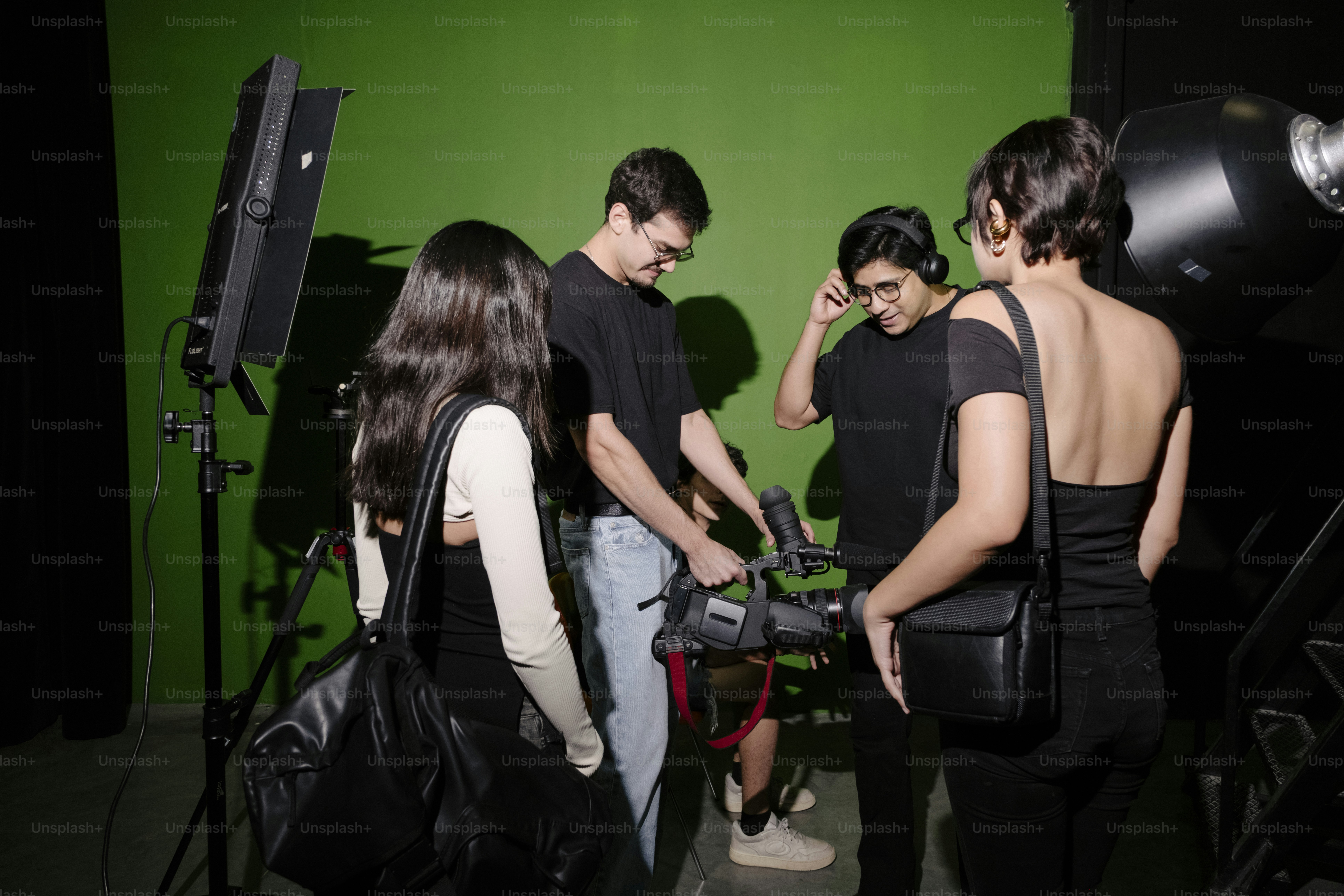 People filming with equipment on green screen