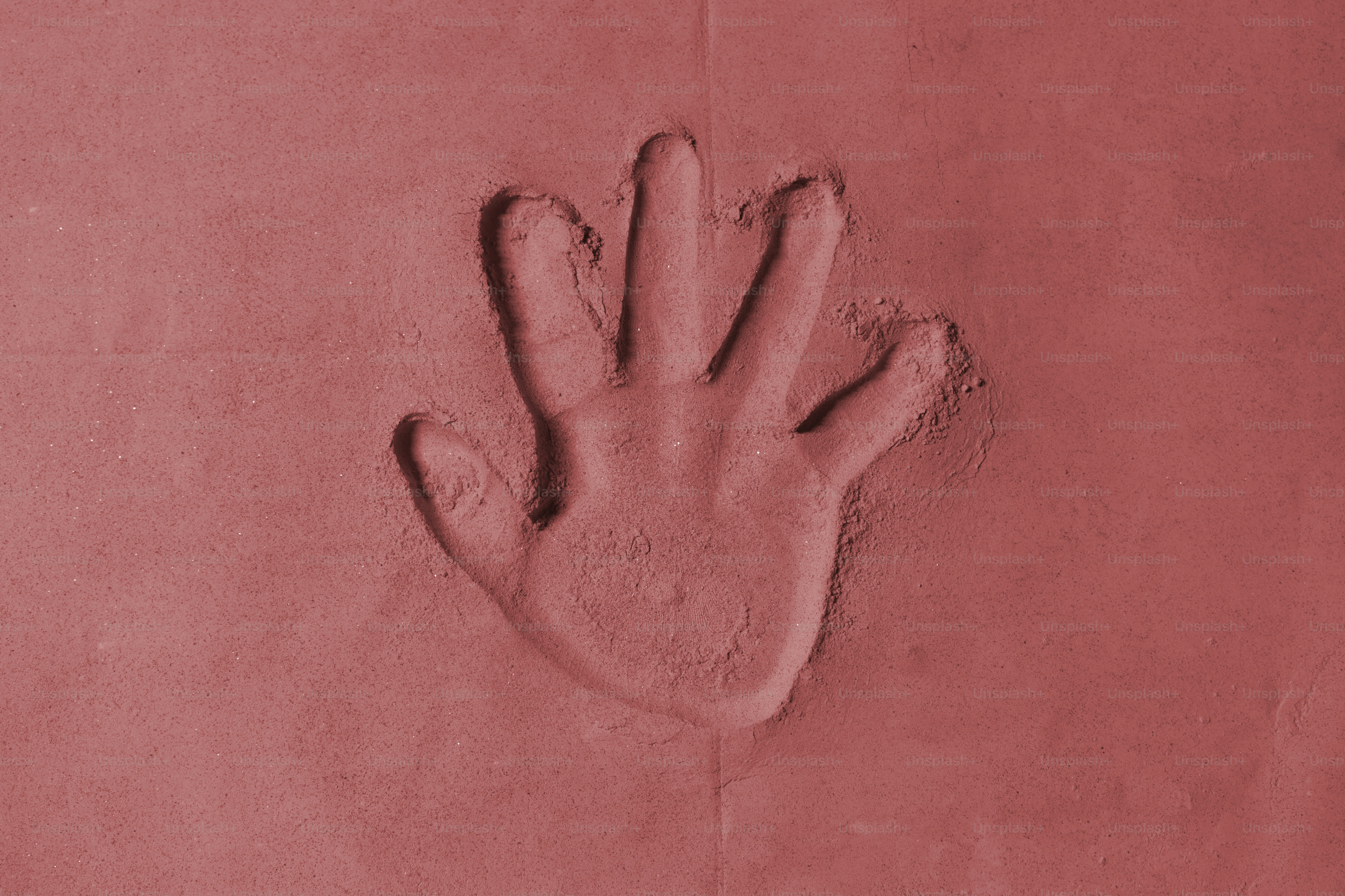Impronta a mano pressata in materiale argilloso rosso