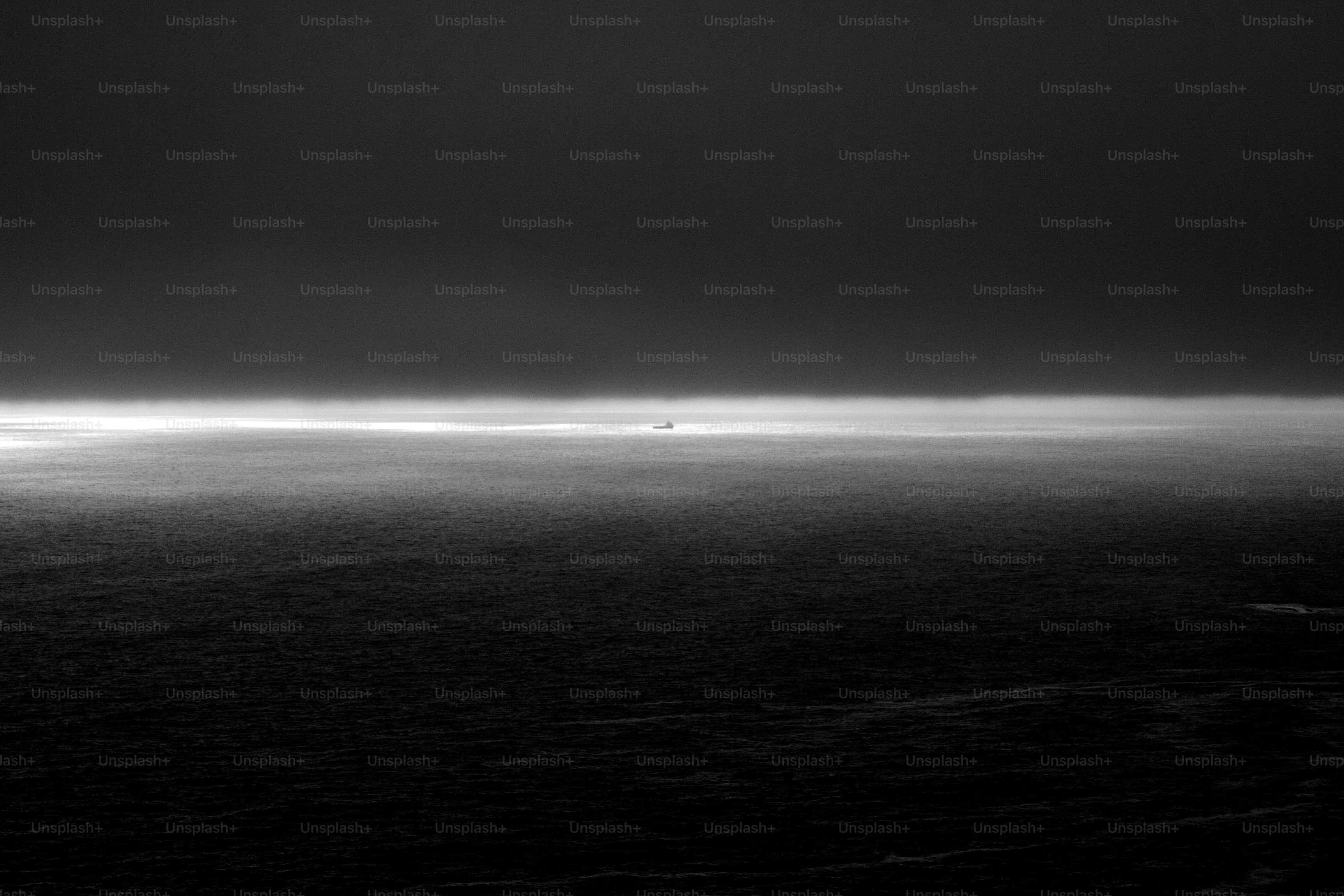 Un avión lejano sobrevuela un océano brumoso.