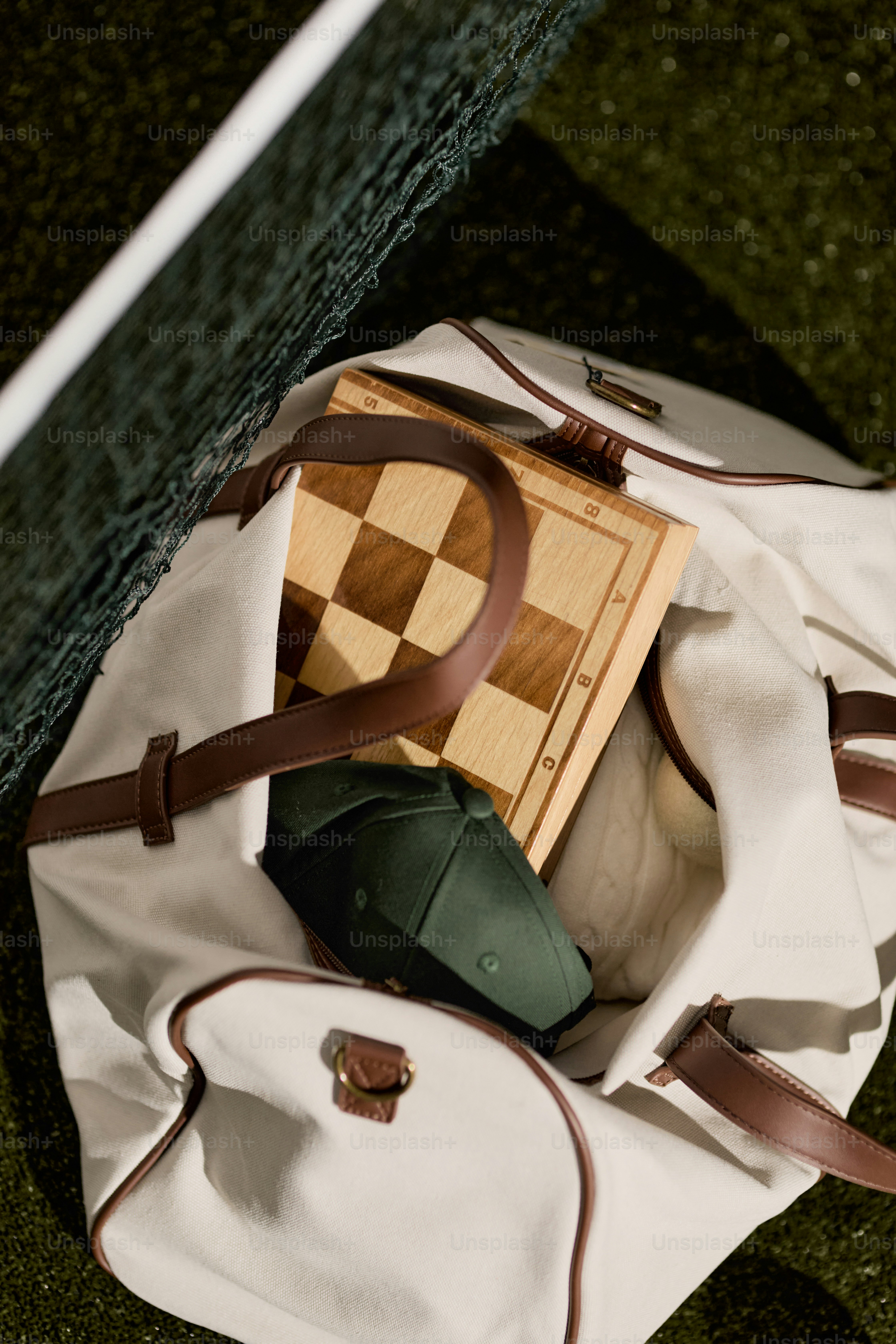 Una borsa da viaggio con scacchiera e cappellino.
