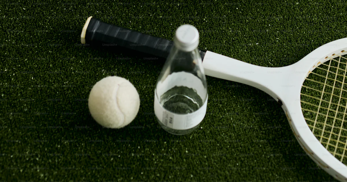 Botel Racket Tennis racket, ball, water bottle, and duffel bag on grass photo ...