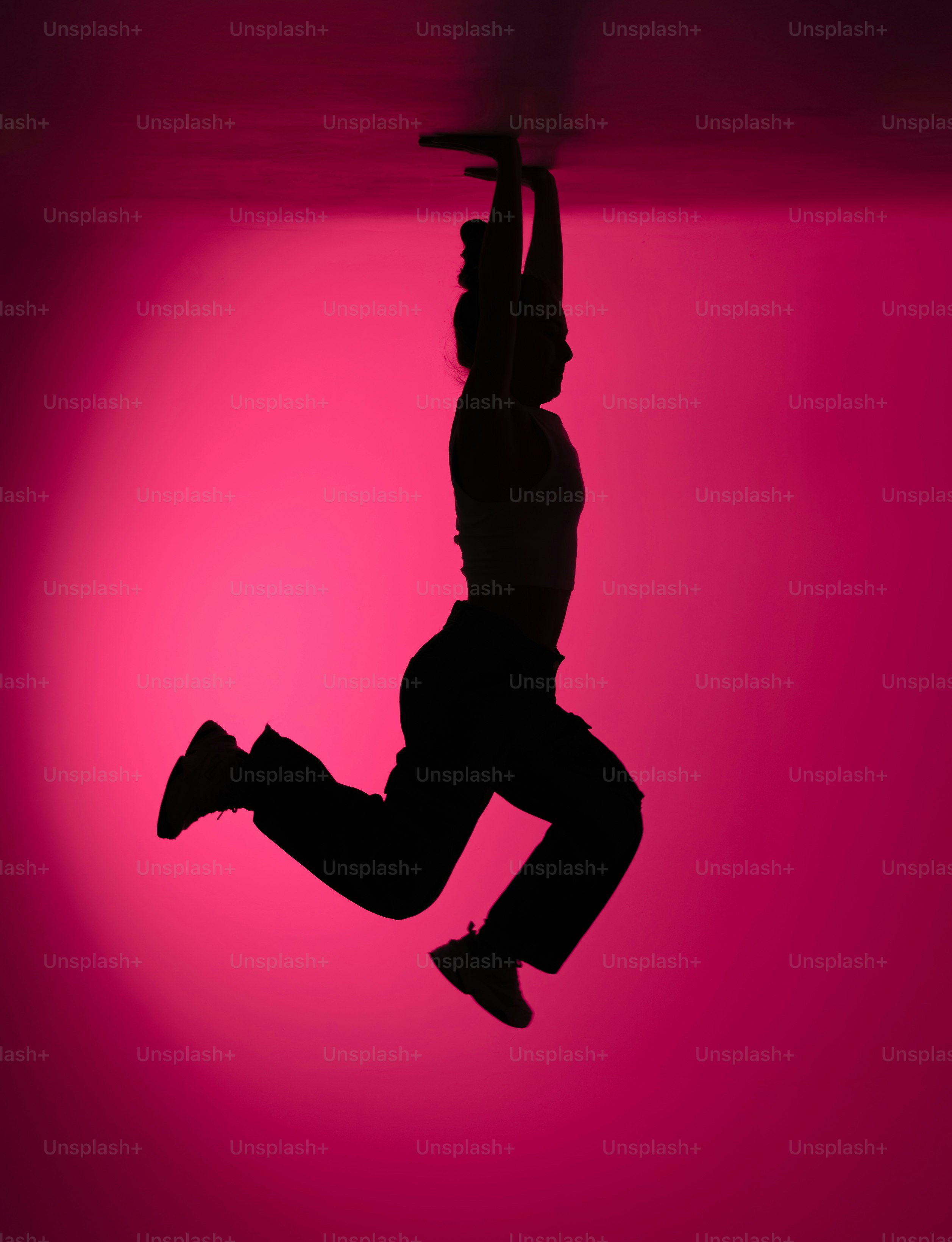 Silhouette of a person hanging from a bar