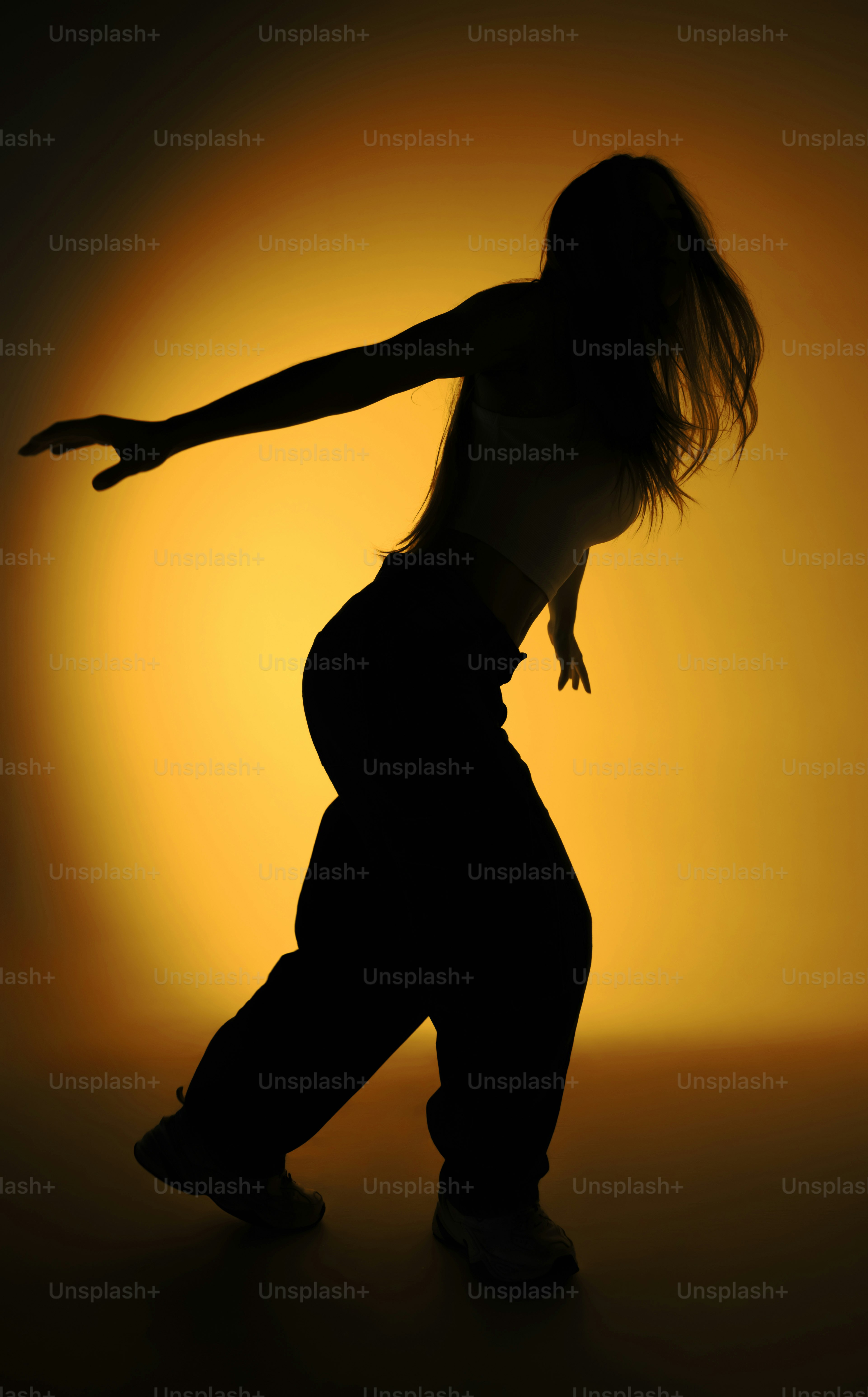 Silhouette of a dancer against a yellow spotlight photo – Profile Image ...