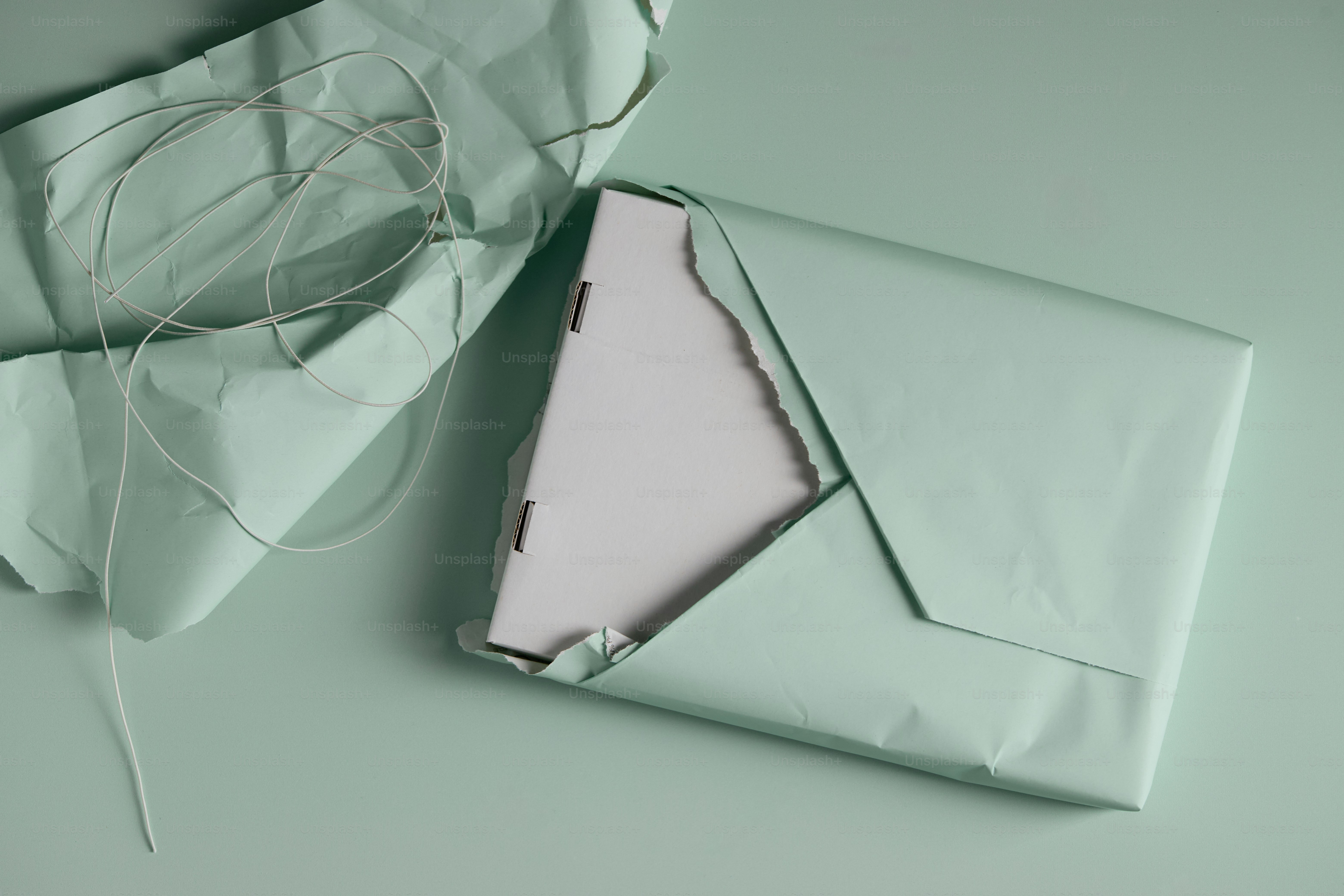 A gift wrapped in pale pink paper with string. photo – Gift Image on ...