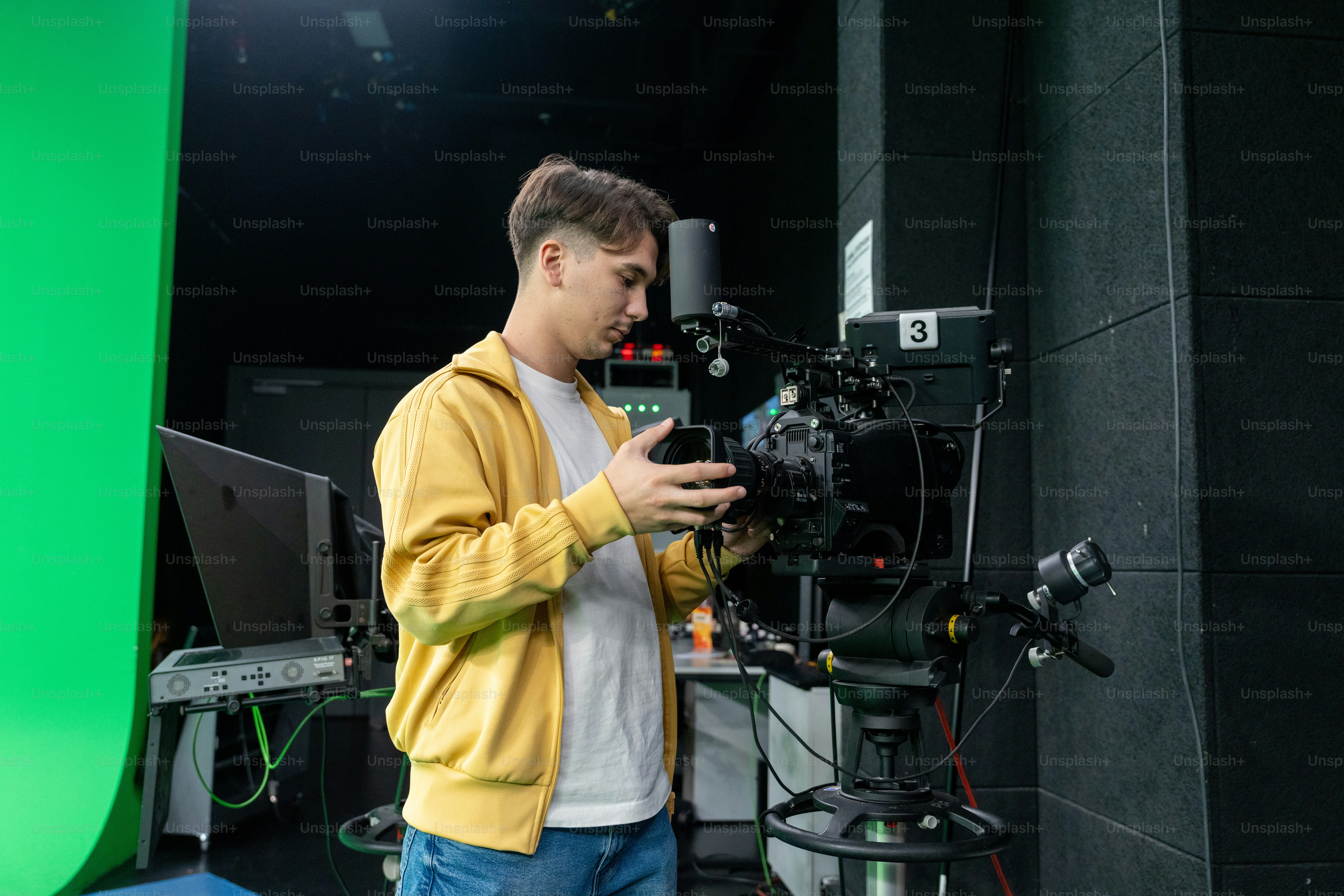 Man adjusting professional video camera in studio