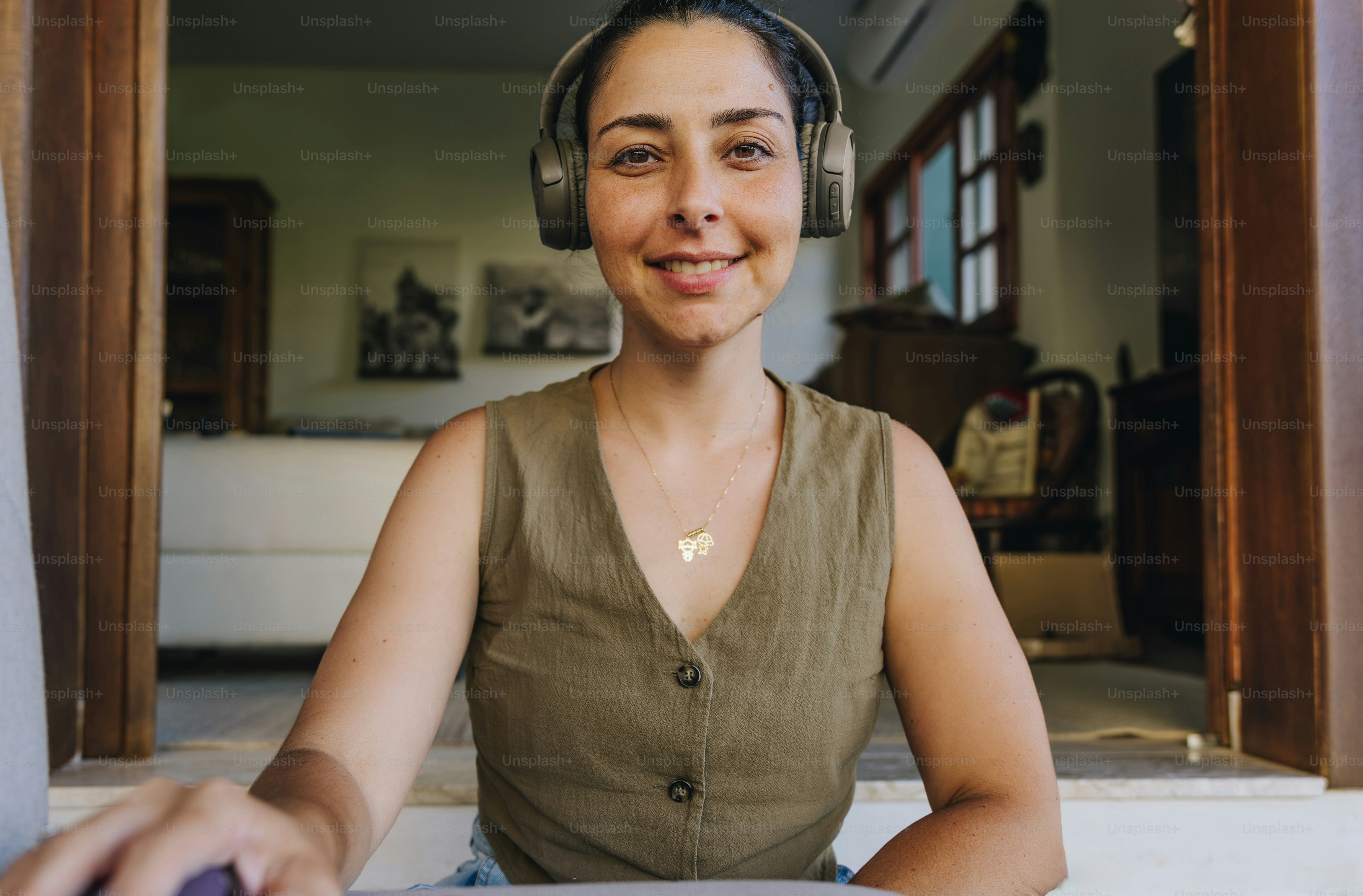 Woman wearing headphones smiles at the camera