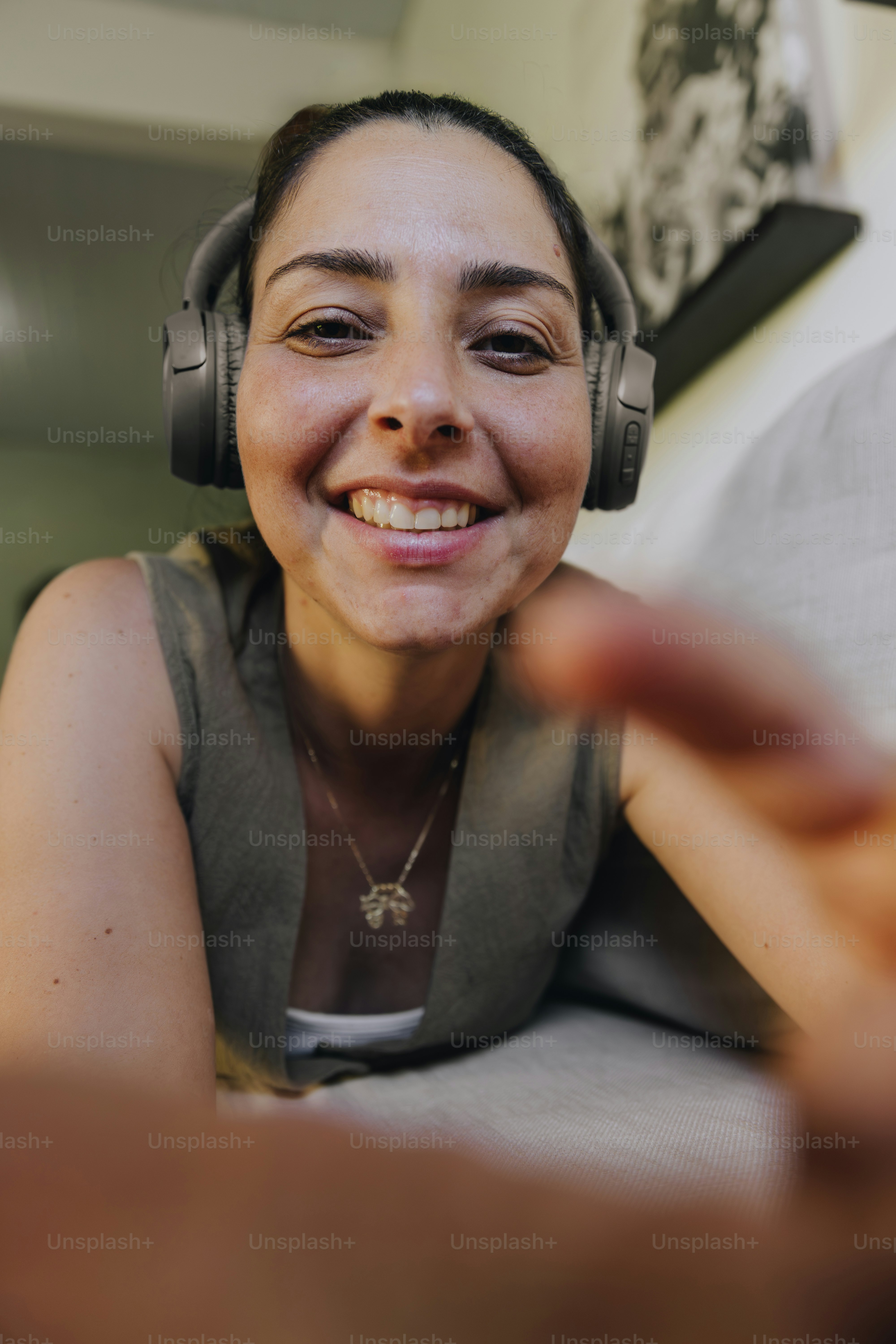 Smiling woman wearing headphones on a couch