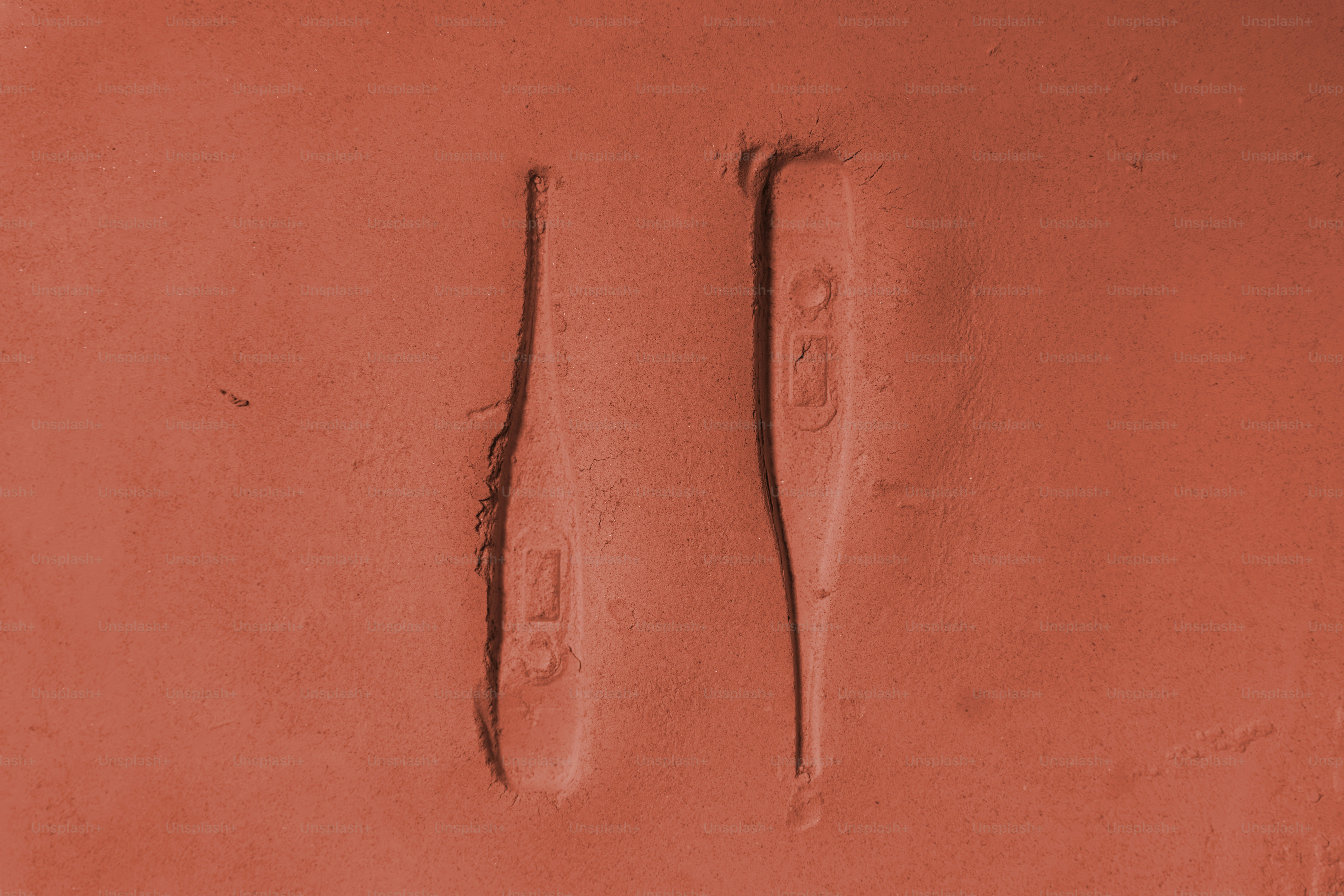 赤い表面に2つのデジタル体温計が置かれています