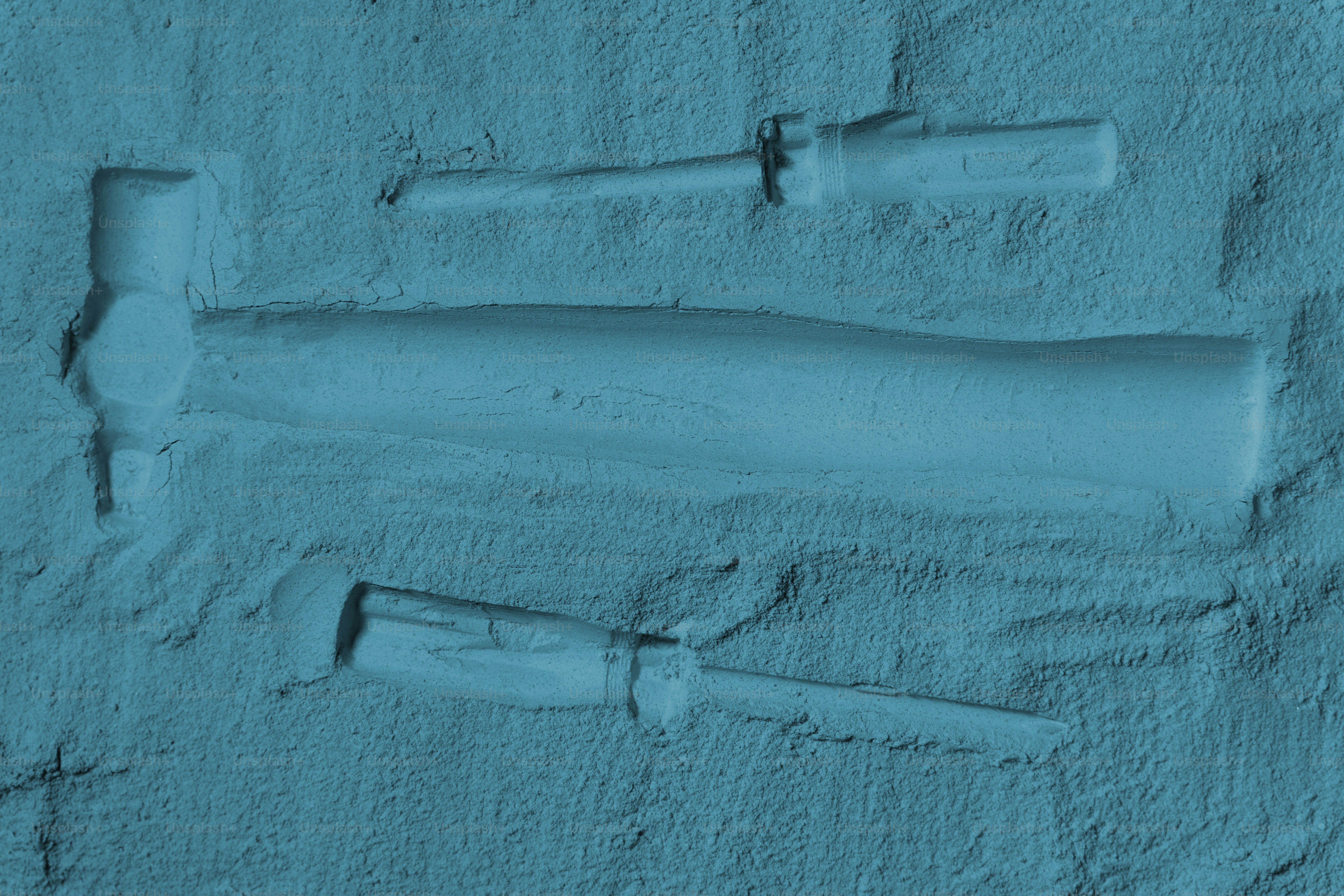 砂に埋め込まれたハンマーとノミ