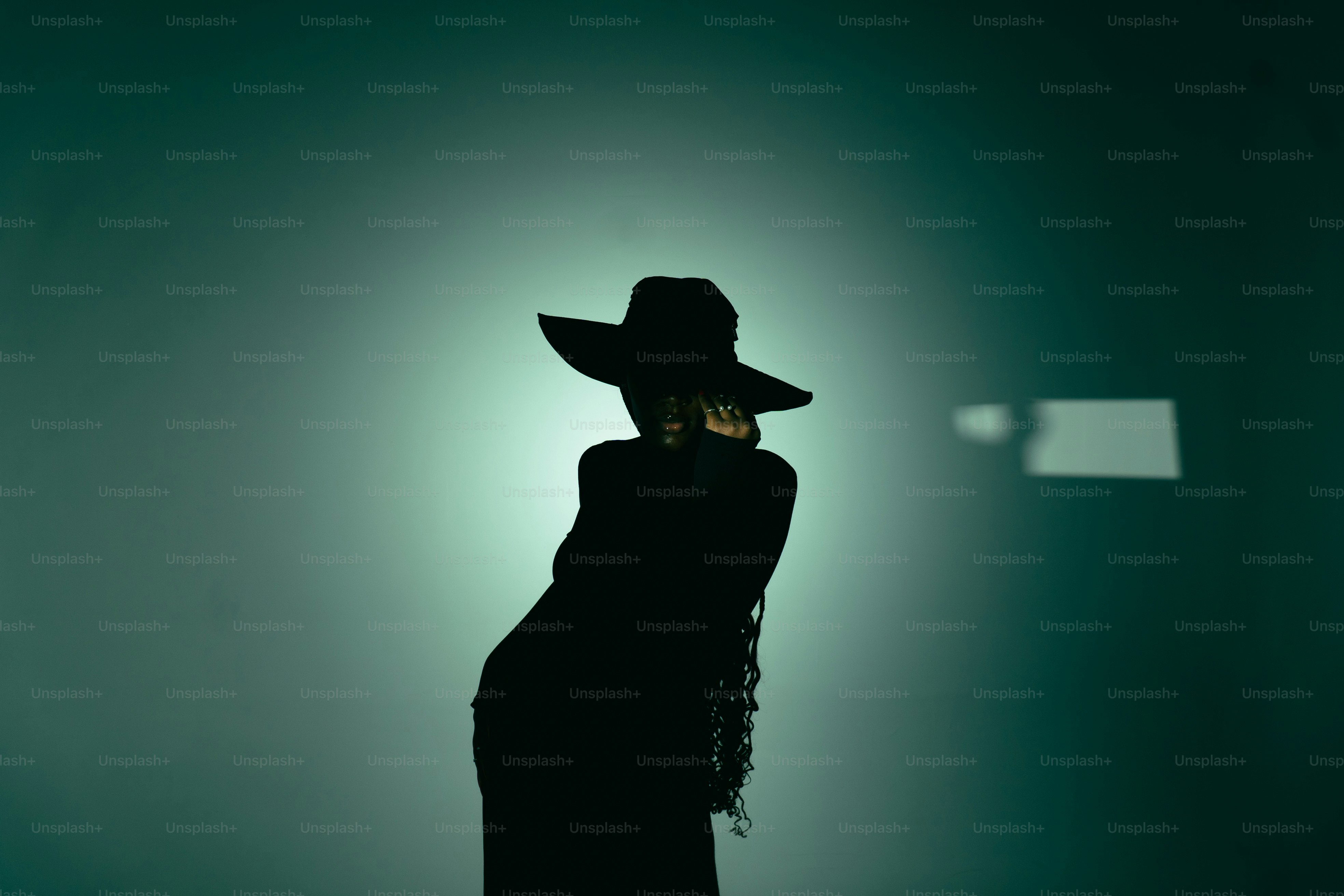 Siluetas de una mujer con un sombrero de ala ancha