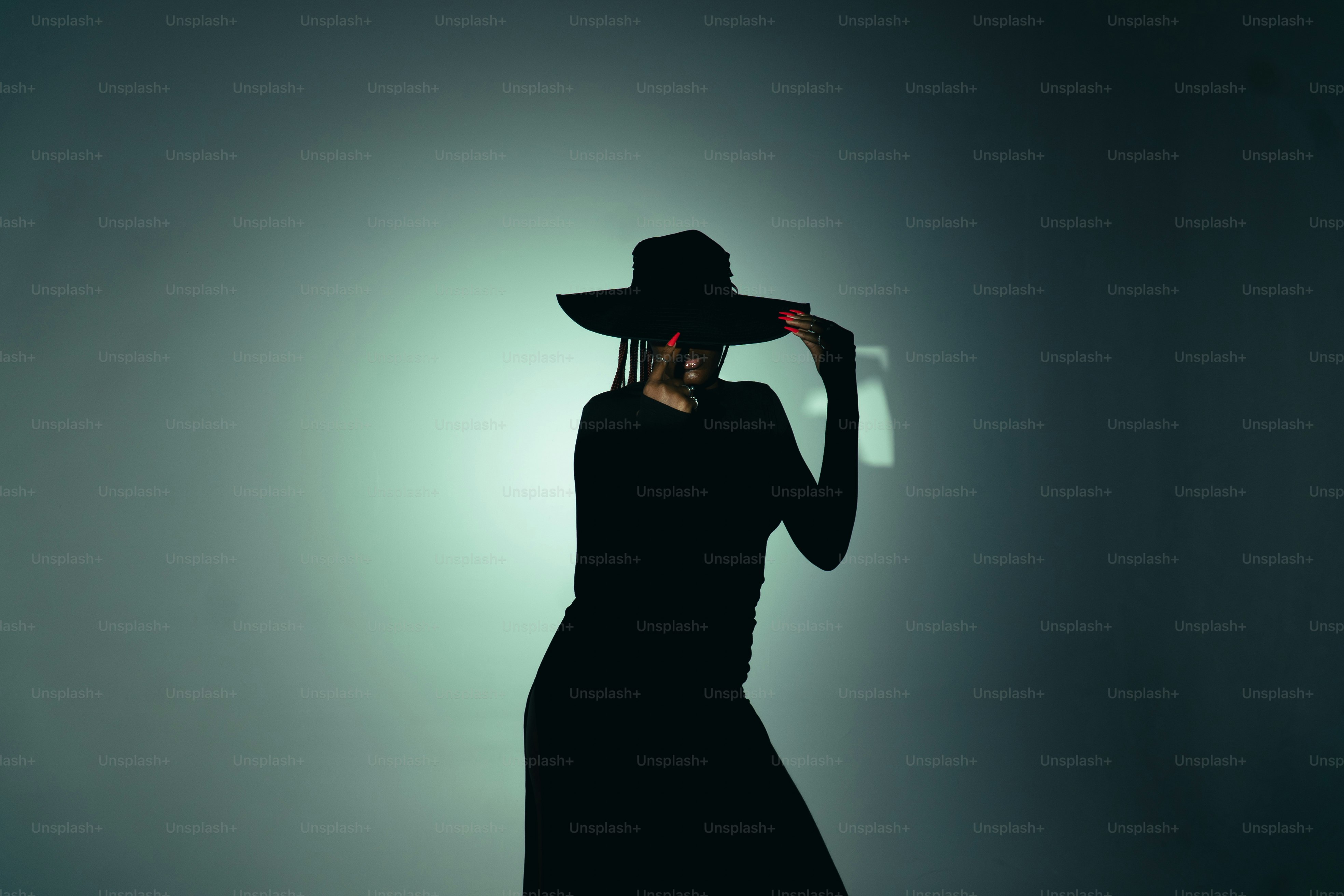 Siluetas de una mujer con un sombrero de ala ancha