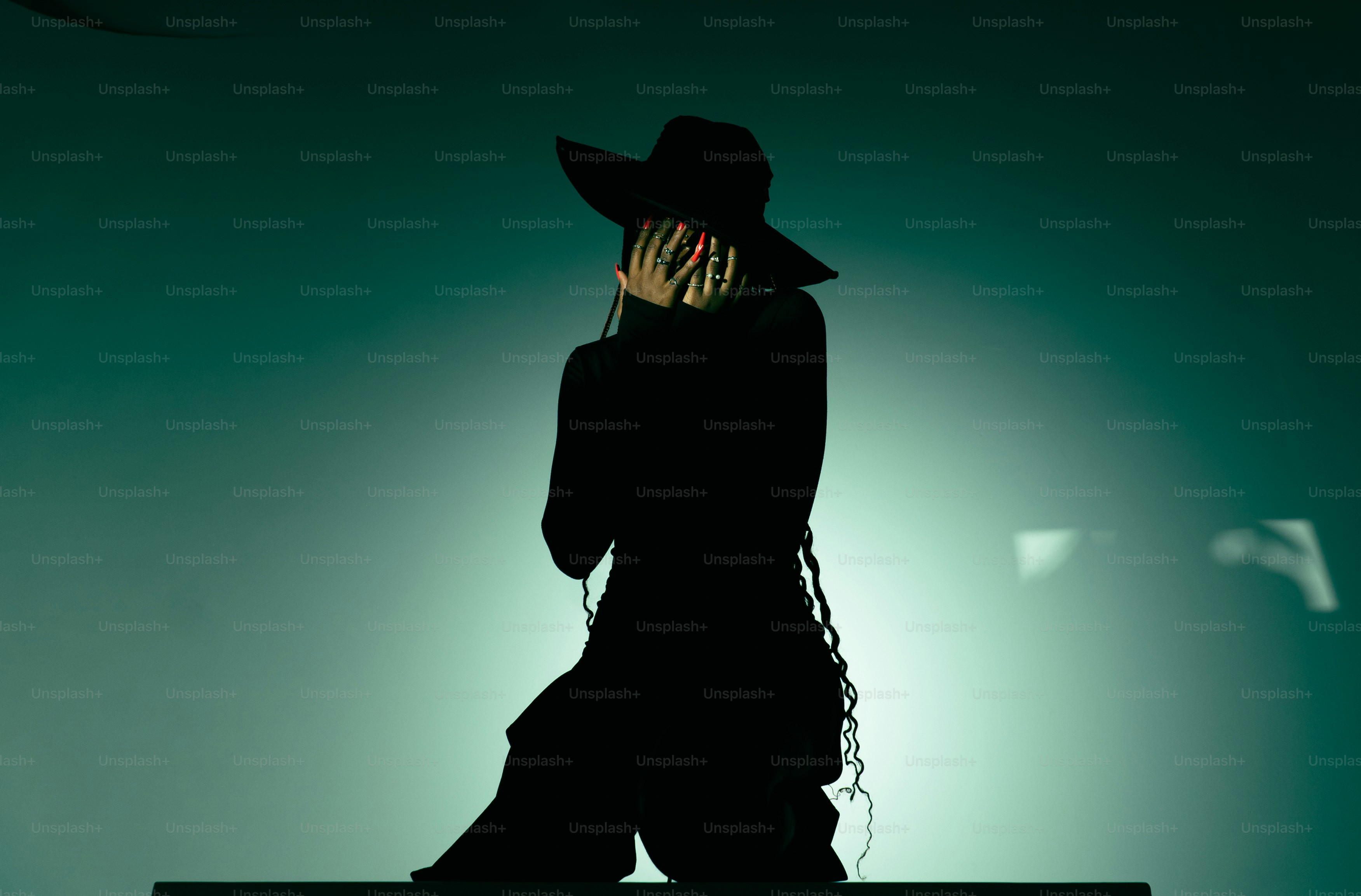 Mujer con sombrero negro y atuendo ocultando el rostro