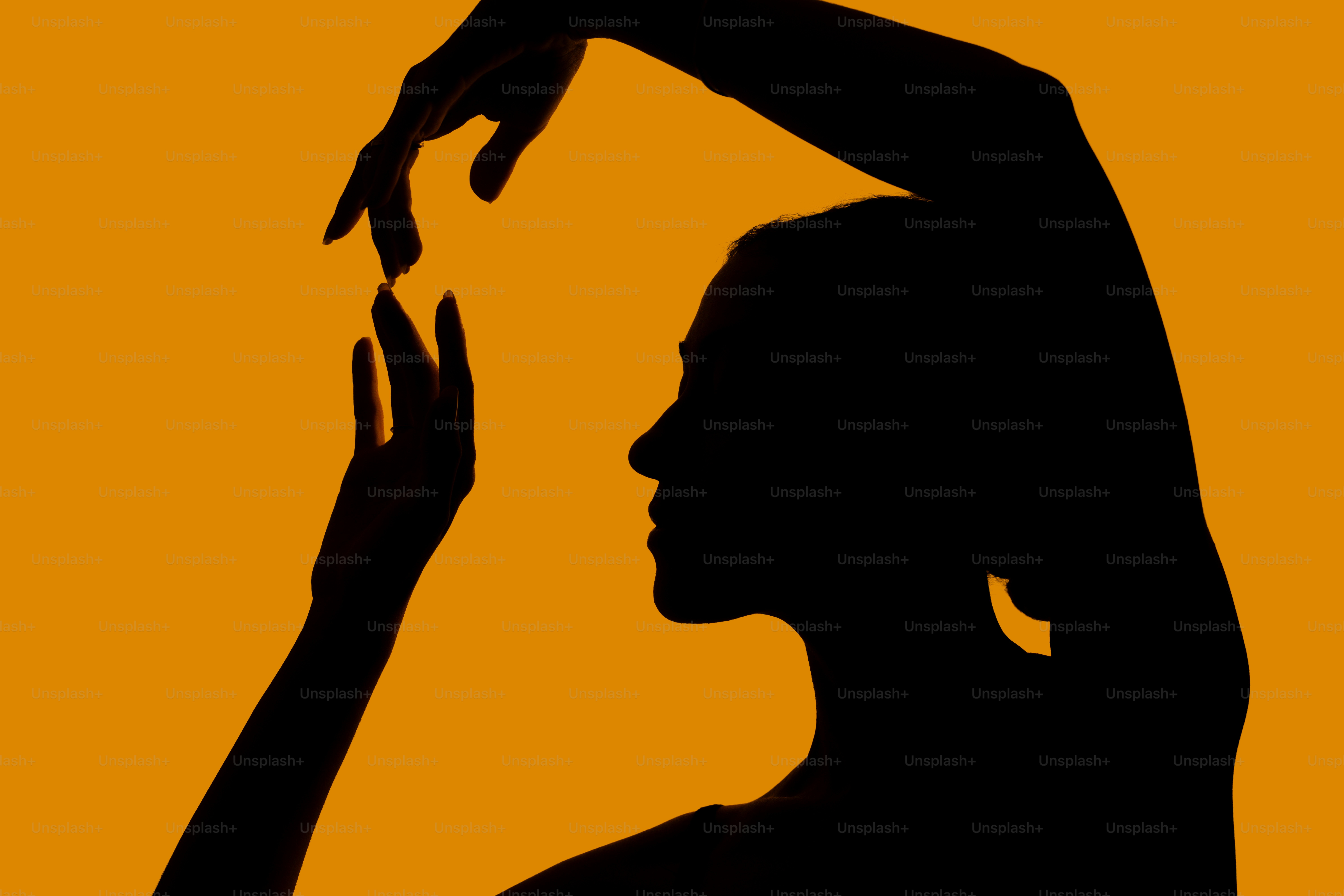Silueta de una mujer bailando sobre fondo naranja