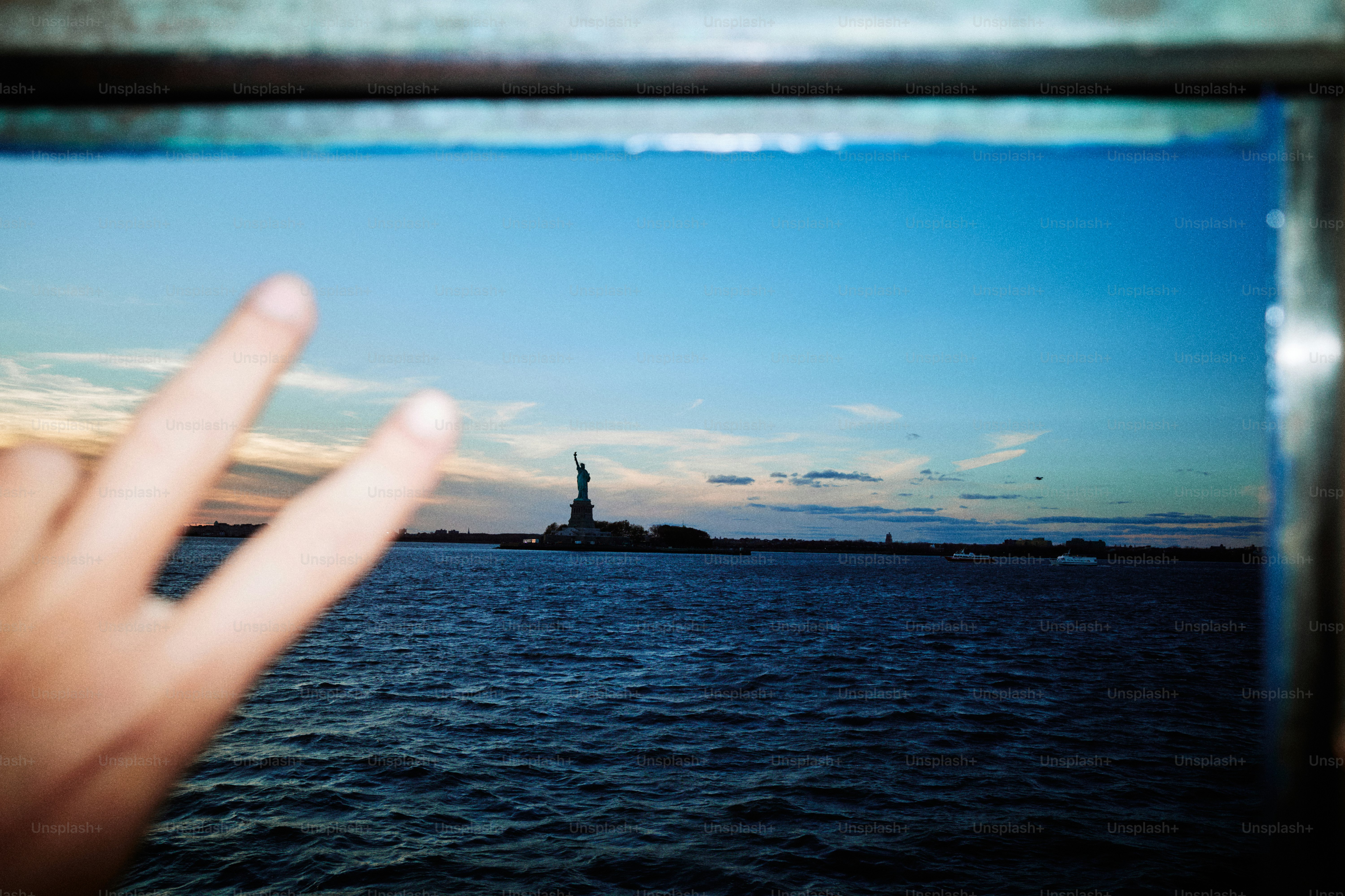 Statue of liberty with hand making peace sign.