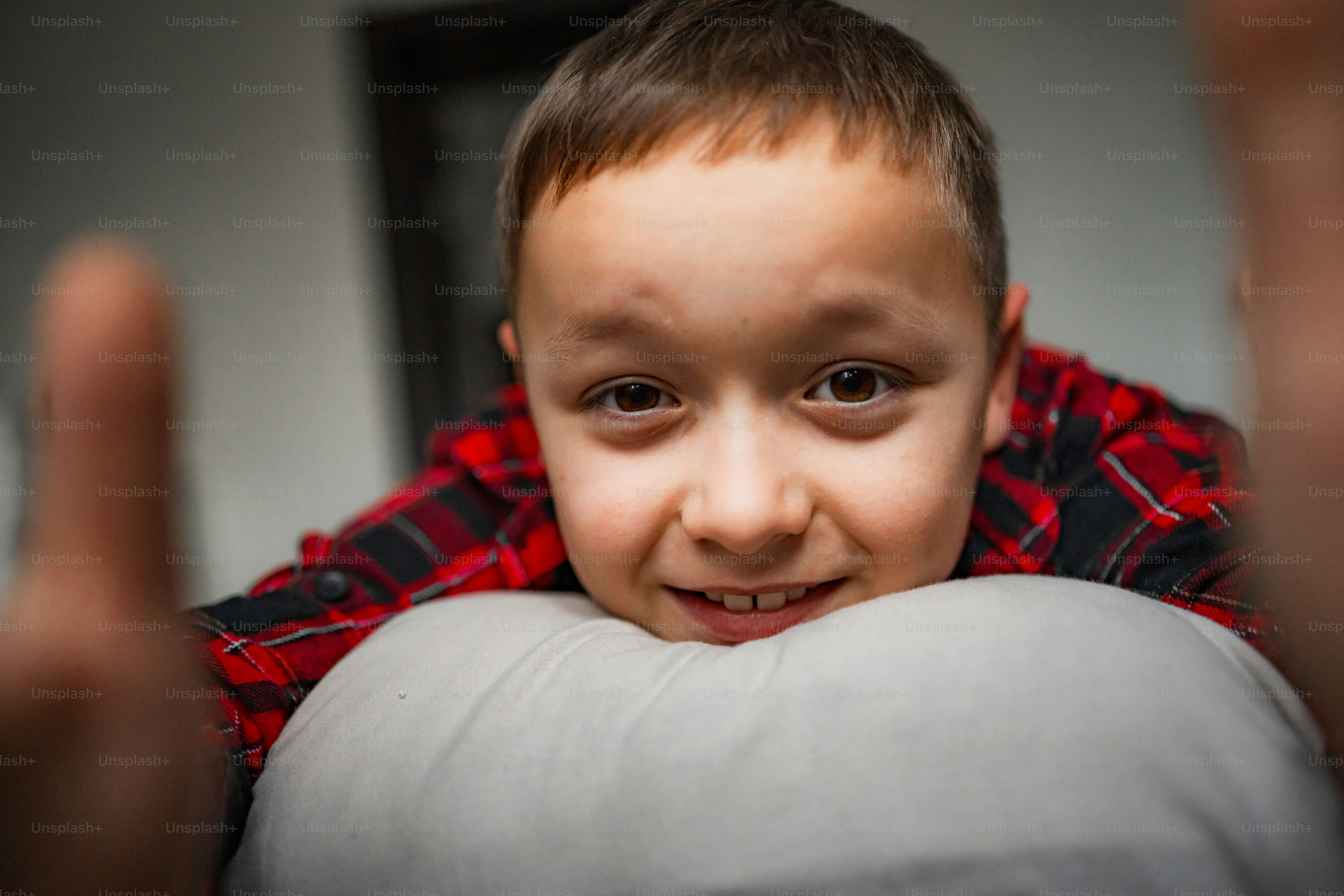 A young boy smiles while lying on a pillow.