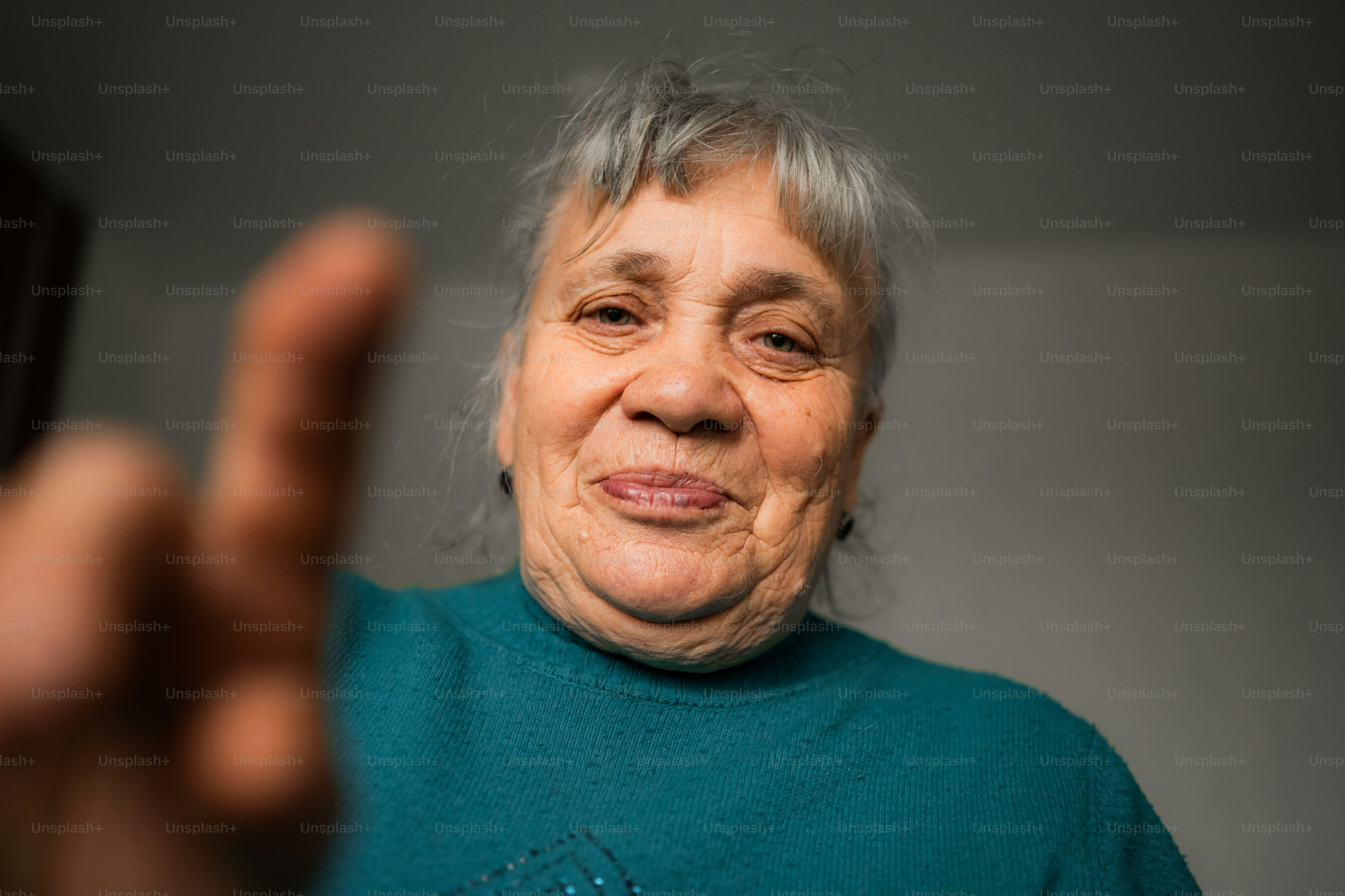 Elderly woman with gray hair smiles at camera.