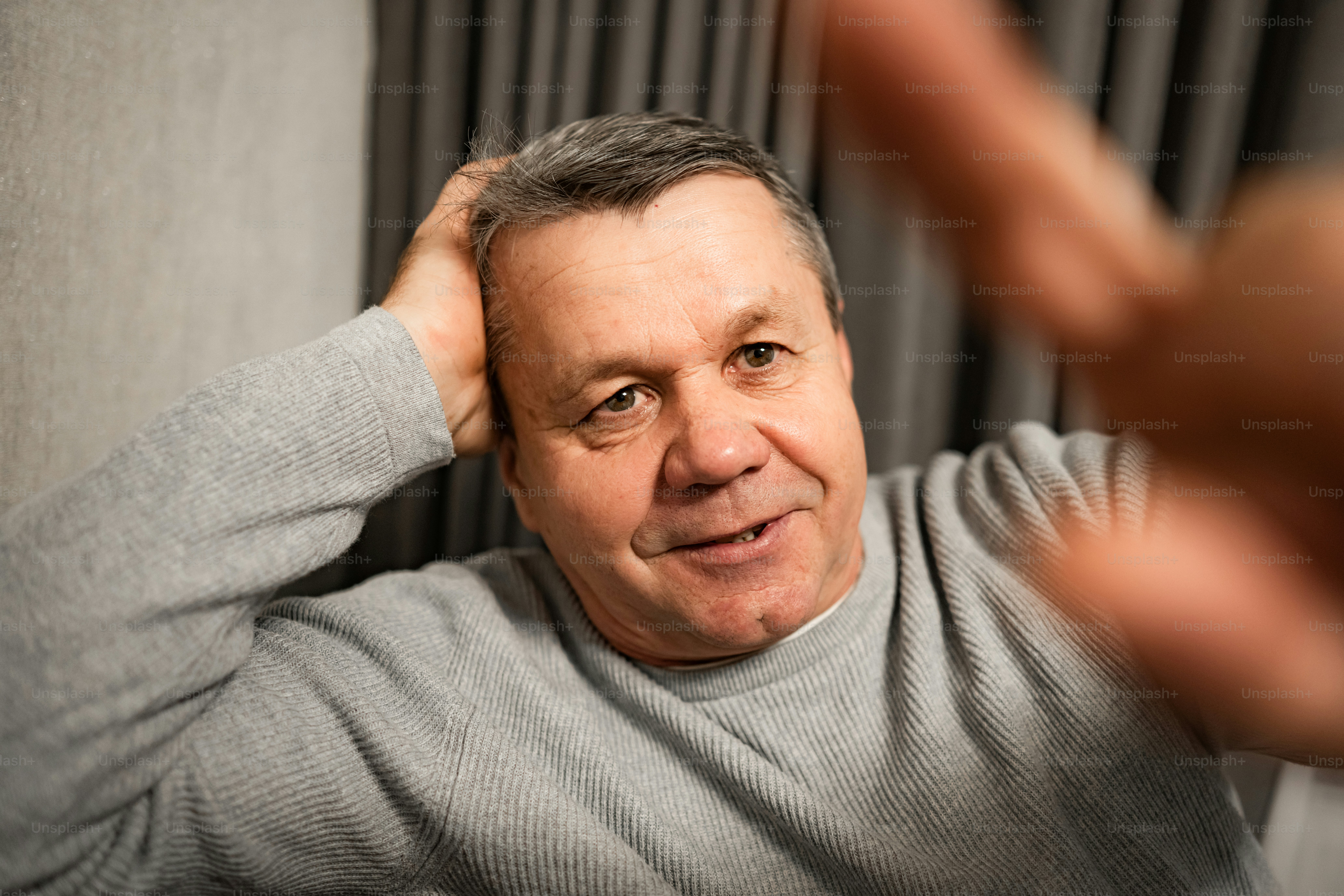 Man with hand on head looking at camera