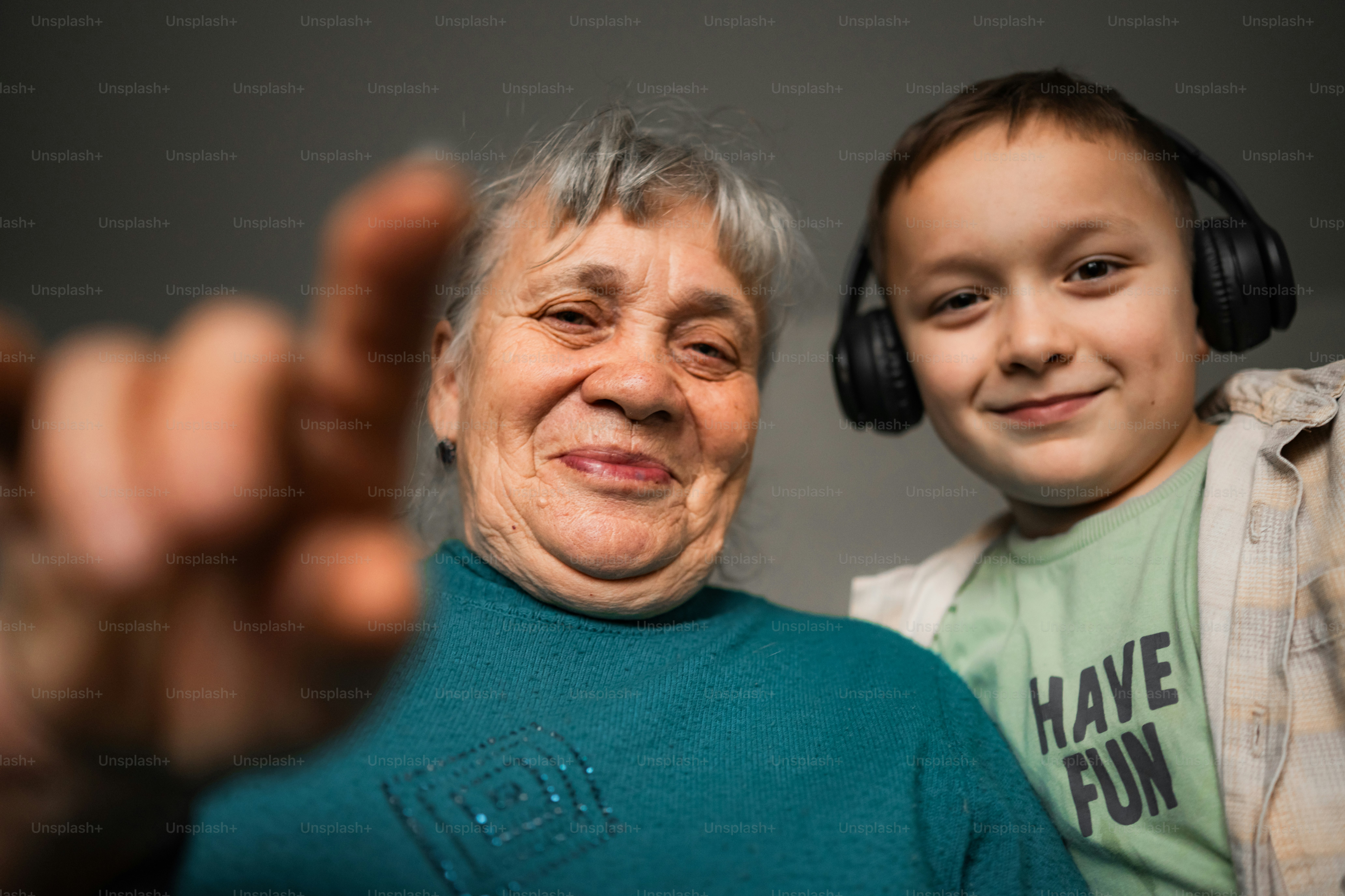 Elderly woman and boy with headphones smiling