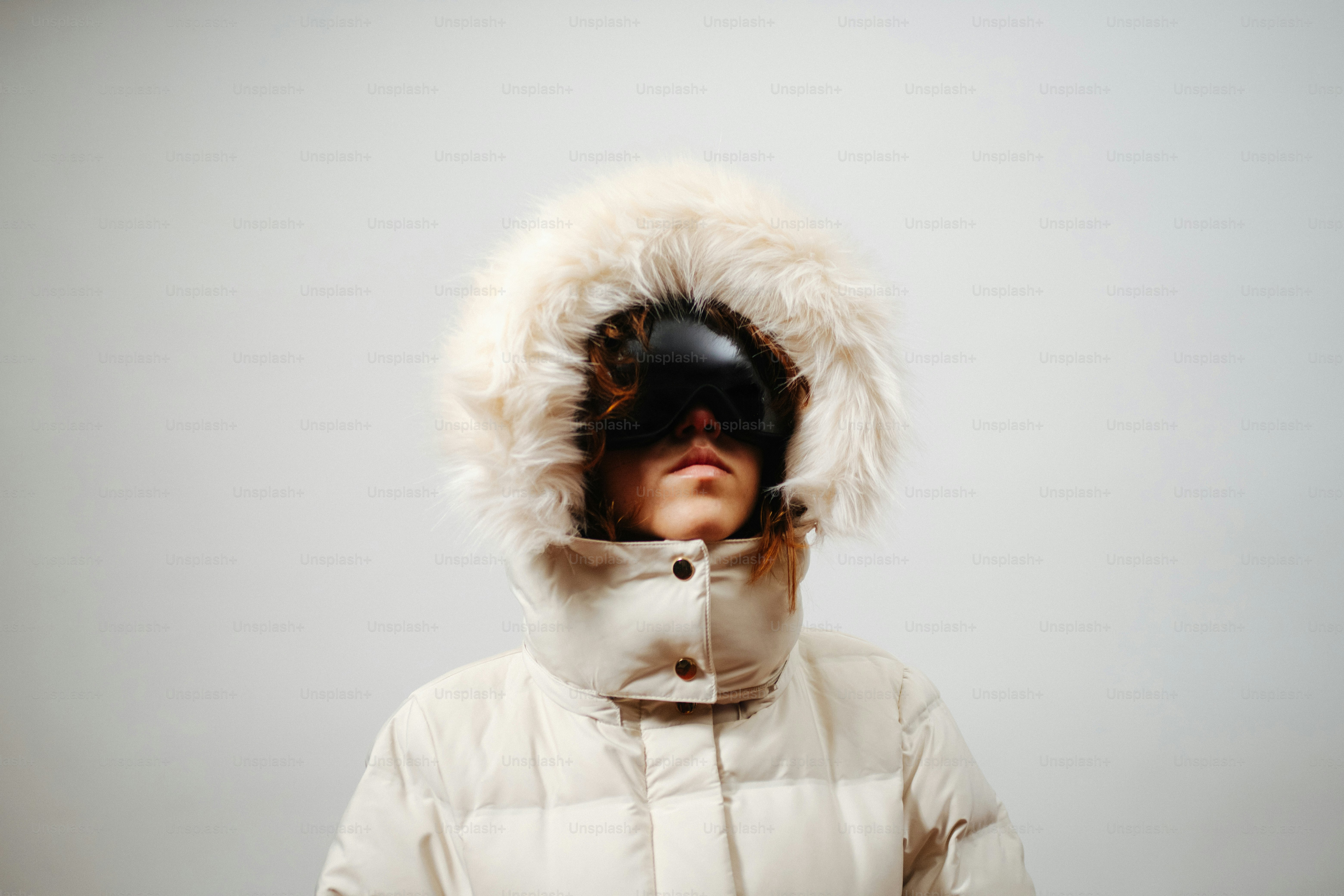 Person wearing a fur-hooded winter coat and goggles