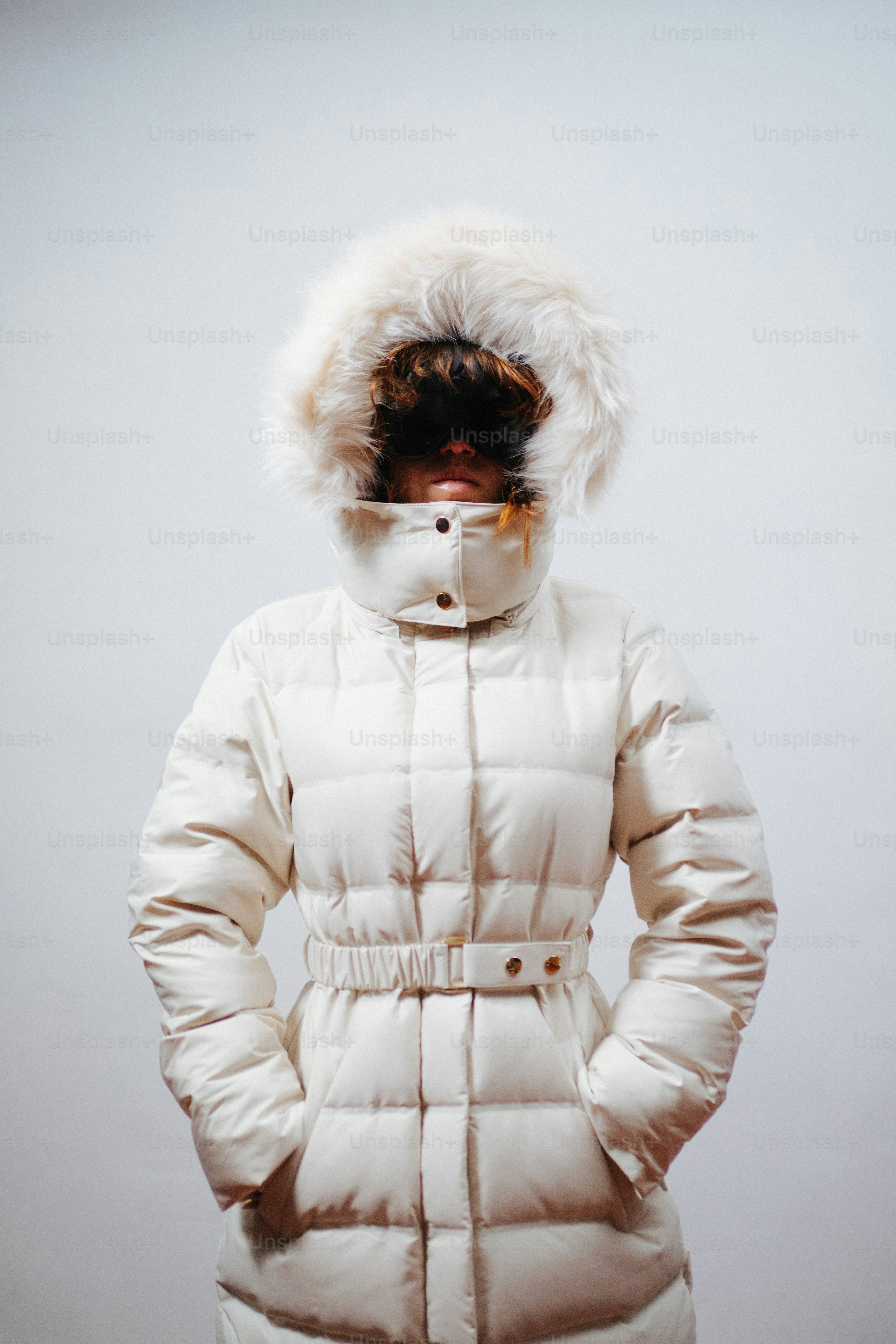 흰색 후드가 달린 겨울 코트를 입은 사람