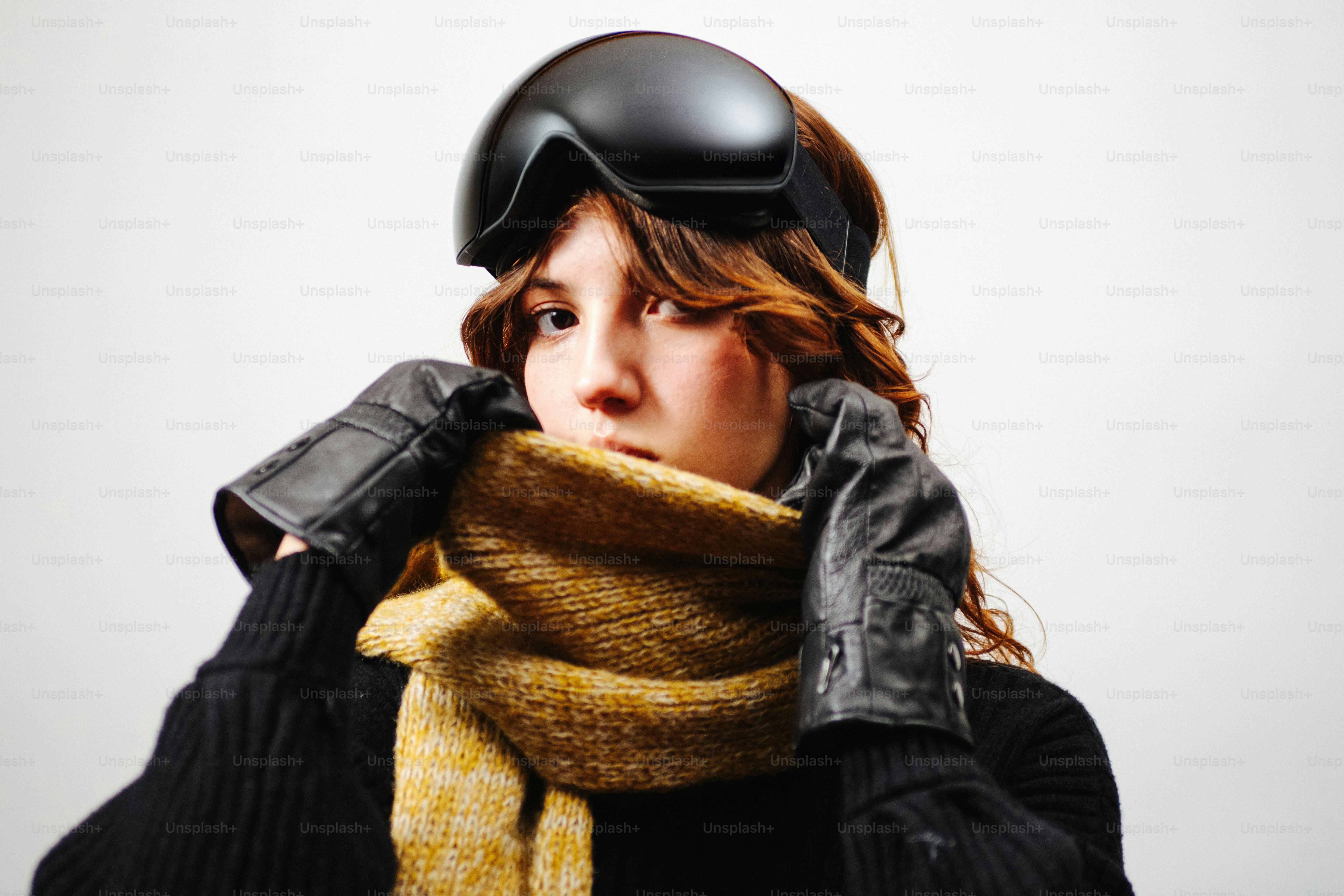 Woman wearing ski goggles, scarf, and gloves