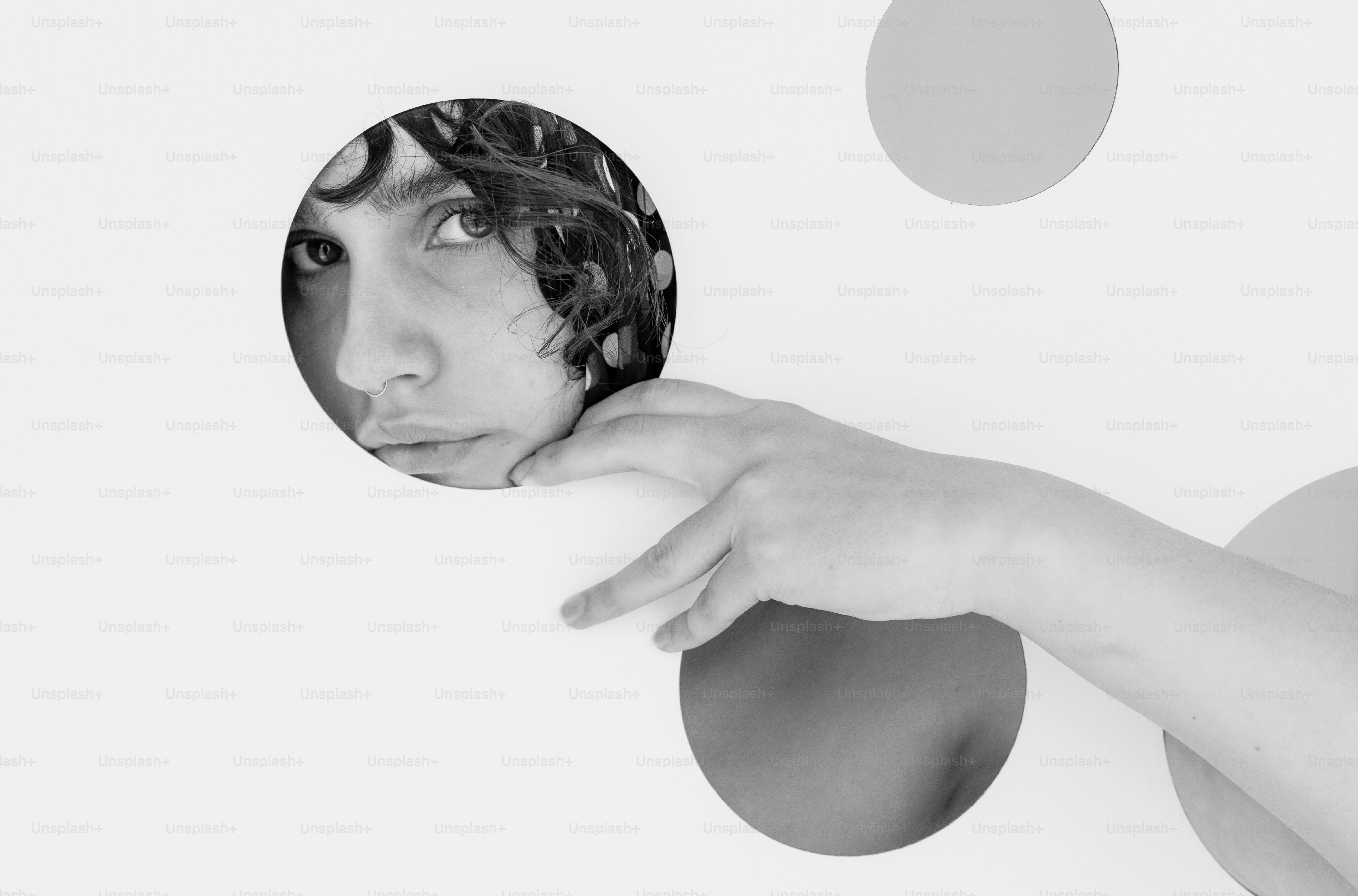 A person peeks through a circular hole in a wall.