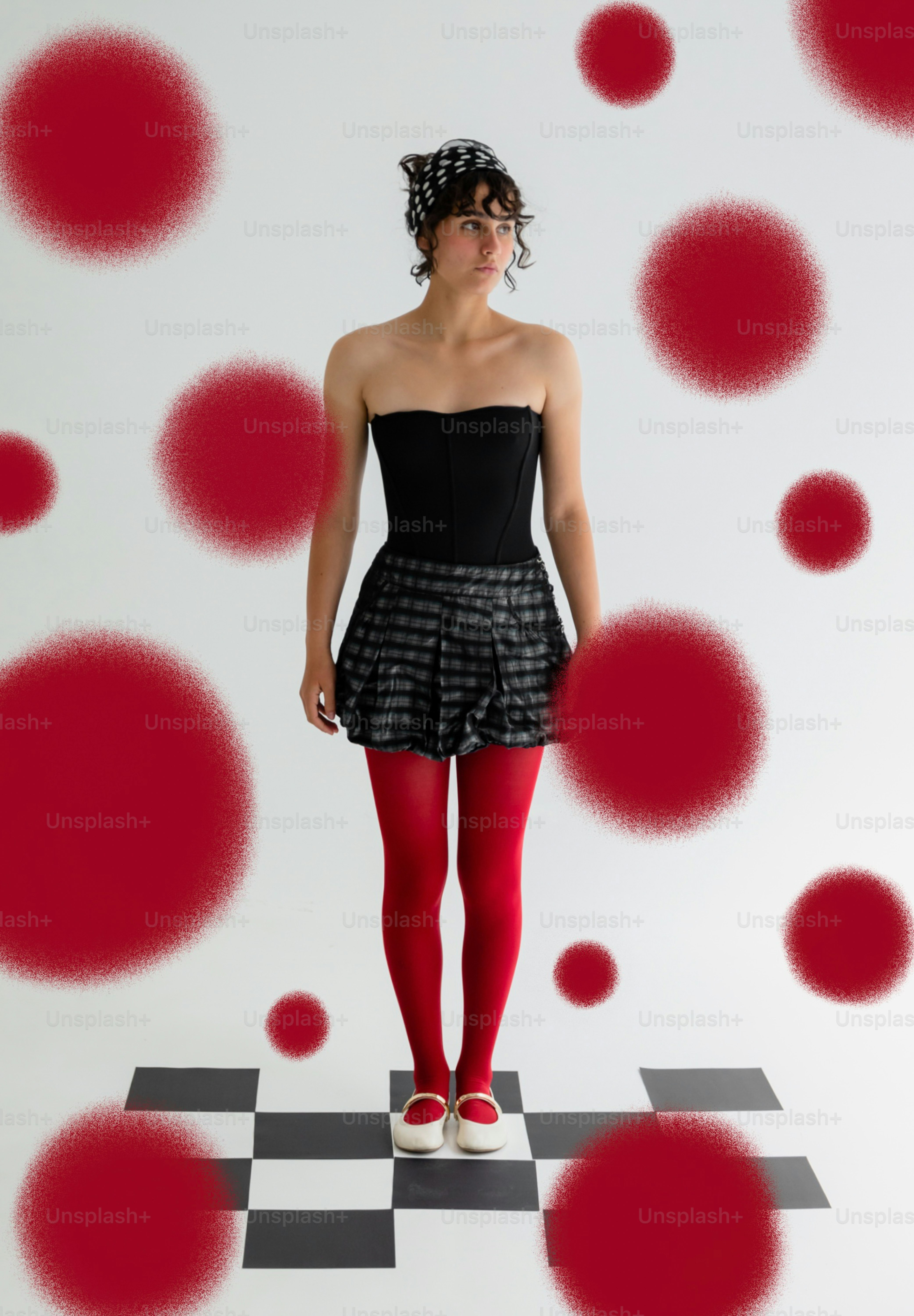 Frau im schwarzen Oberteil, kariertem Rock, roten Strumpfhosen, roten Schuhen